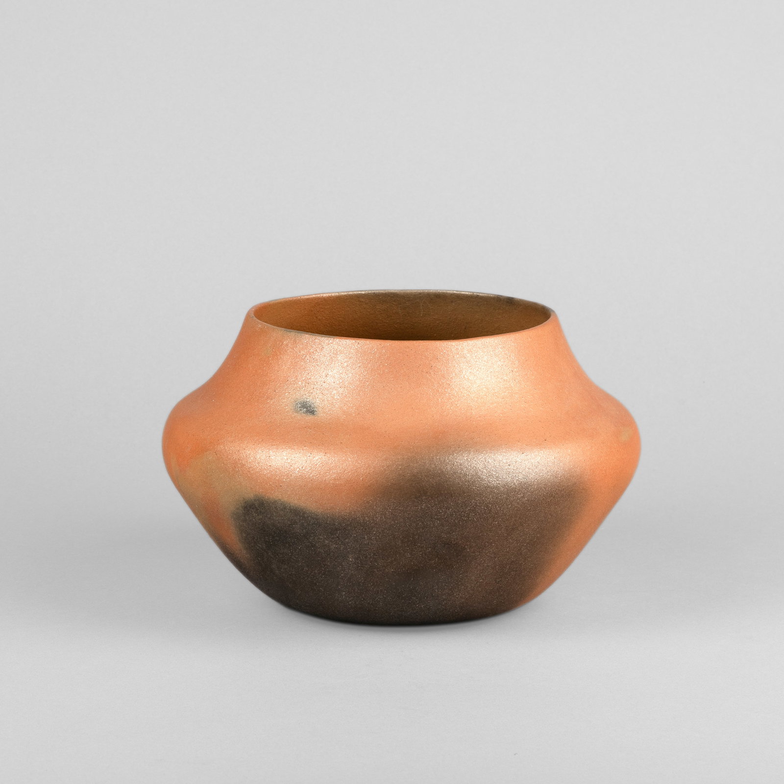 Angie Yazzie, Micaceous Shouldered Pot with Fire Clouds, 2004: Angie Yazzie Taos, b. 1965 Micaceous Shouldered Pot with Fire Clouds, 2004 fired micaceous clay inscribed: Angie Yazzie Taos Pueblo 2004 height: 5 3/4 x diameter: 9 3/8 in. (14.6 x 23.8 cm.) Private