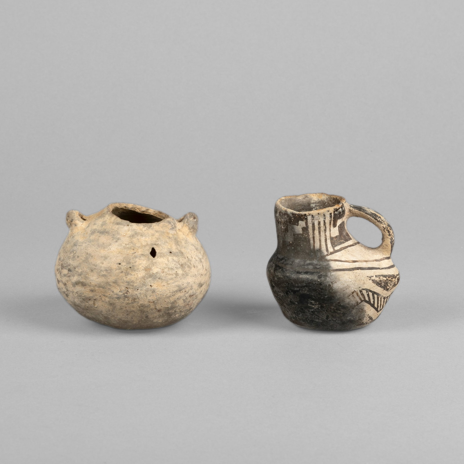 Ancestral Pueblo, Two Handled Vessels, ca. 1250: Duck Pot + Canteen: Ancestral Pueblo Two Handled Vessels, ca. 1250: Duck Pot + Canteen fired clay, natural pigment larger height: 2 3/4 x diameter: 4 in. (7 x 10.2 cm.), smaller: 2 7/8 x 2 7/8 x 3 in. (7.3 x 7.3 x 7.6 cm