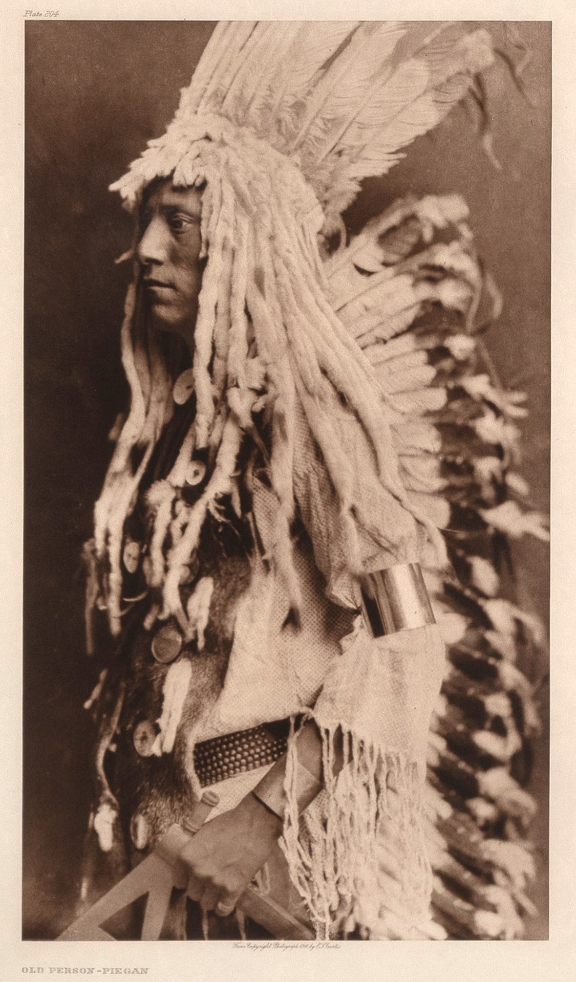 Edward S. Curtis, Old Person - Piegan, 1911: Edward S. Curtis 1868 - 1952 Old Person - Piegan, 1911 photogravure on Japanese vellum inscribed in plate, upper left: Plate 204 titled in plate, lower left: OLD PERSON - PIEGAN inscribed in plate, lo