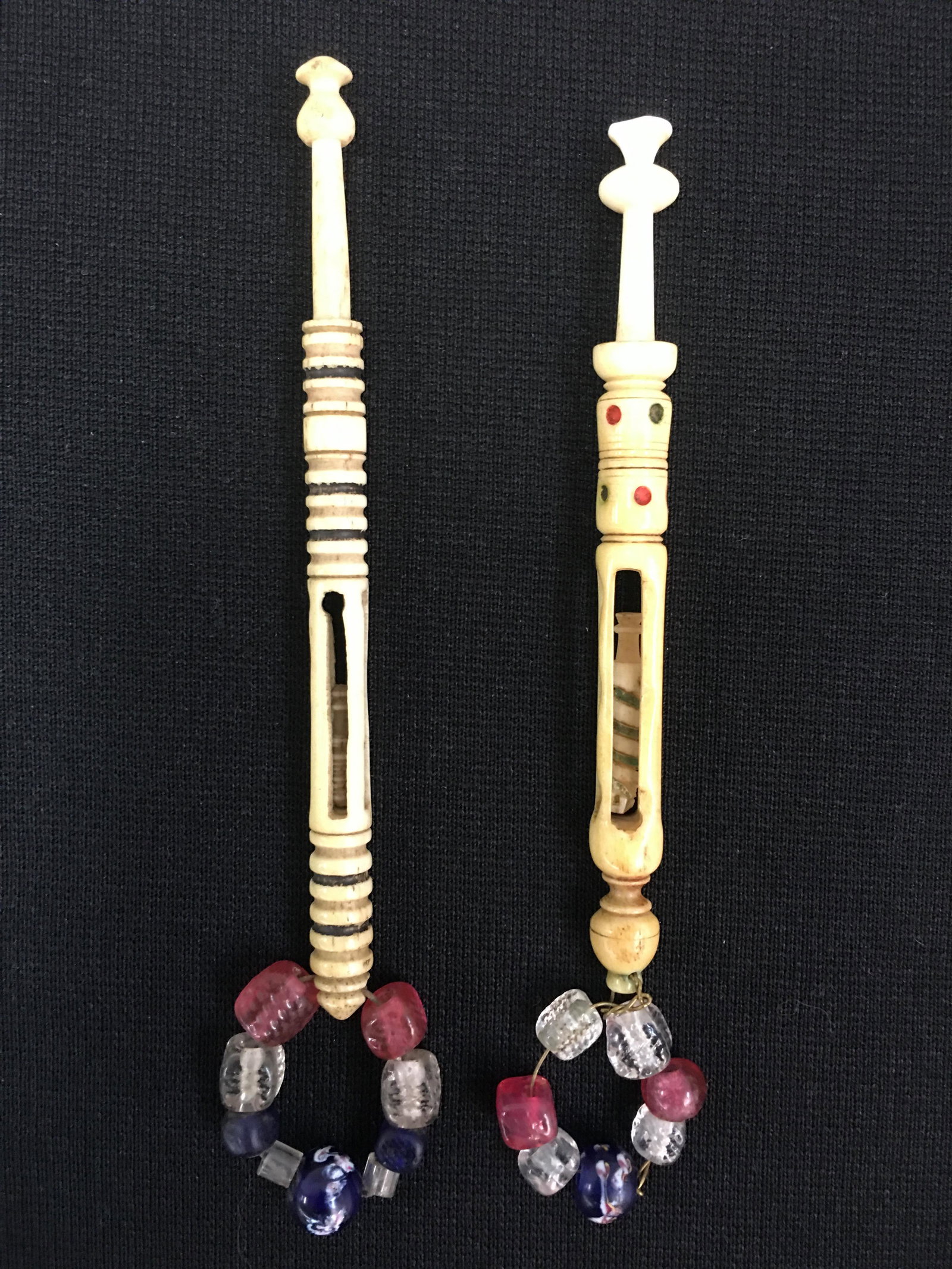 (2) Mother & Babe Antique Bobbins: (2) Antique Bone English Midland Mother and Babe Lace Spangled Bobbins. (1) with carved and colored rings, 4". (1) spotted and rings, carved spiral on babe, loss to bottom tip,3.75".