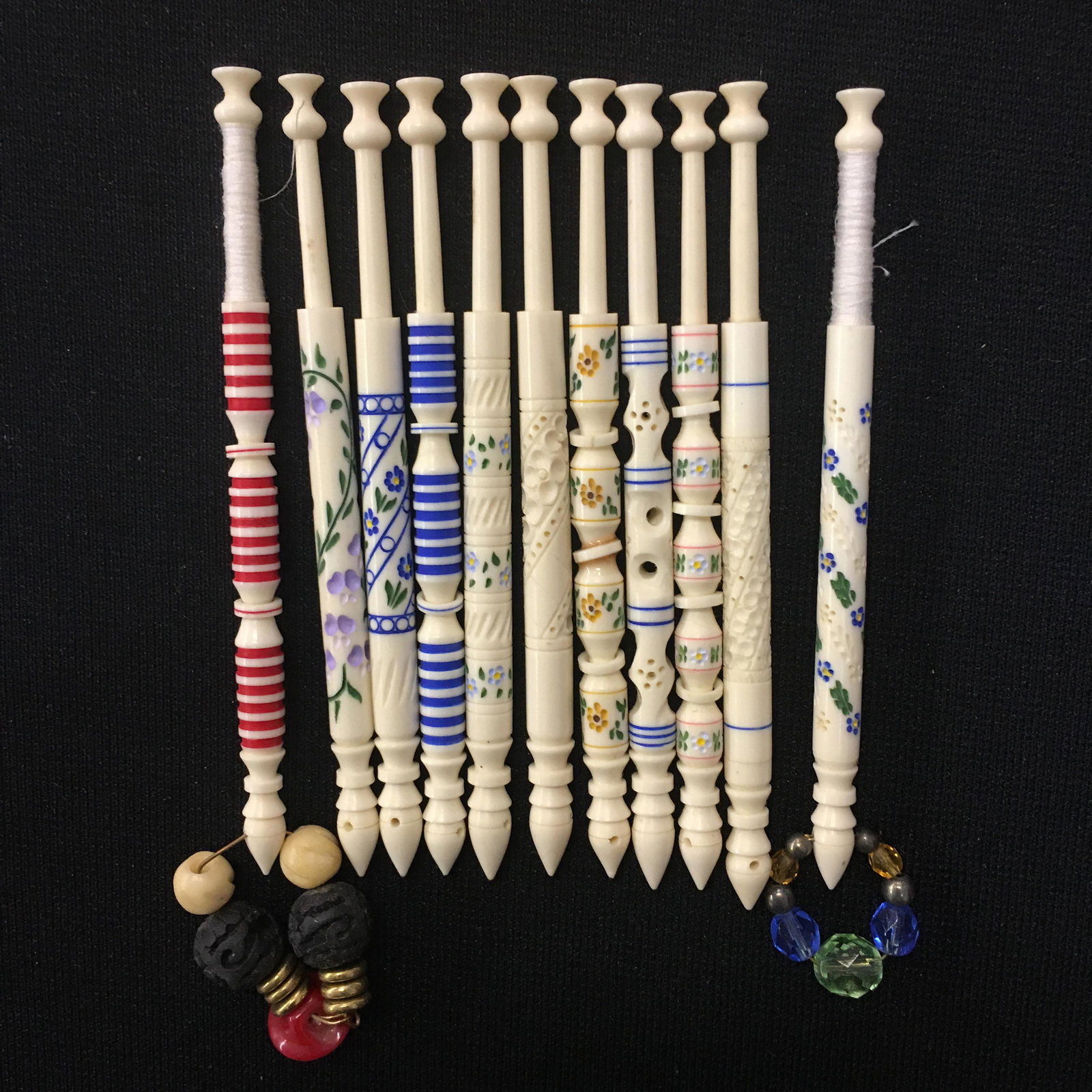 (11) Painted A.R. Archer Bone Lace Bobbins: (11) Painted A.R. Archer Bone Lace Bobbins. Various designs, two spangled, four have gingles but one has been glued. 3.75"