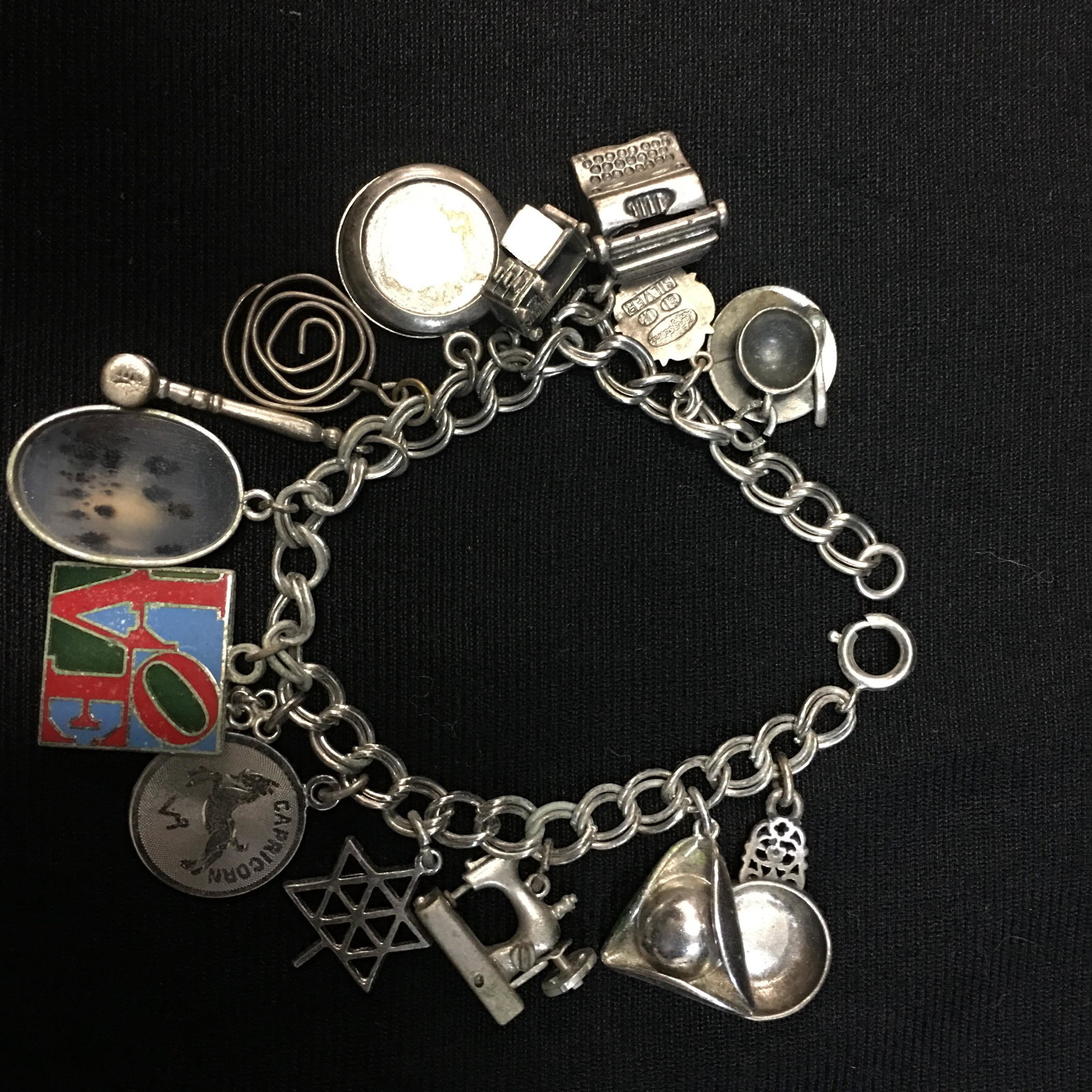 Sterling Charm Bracelet: Sterling Charm Bracelet. A Danecraft sterling chain with (13) charms, a few of which are not marked. 53g