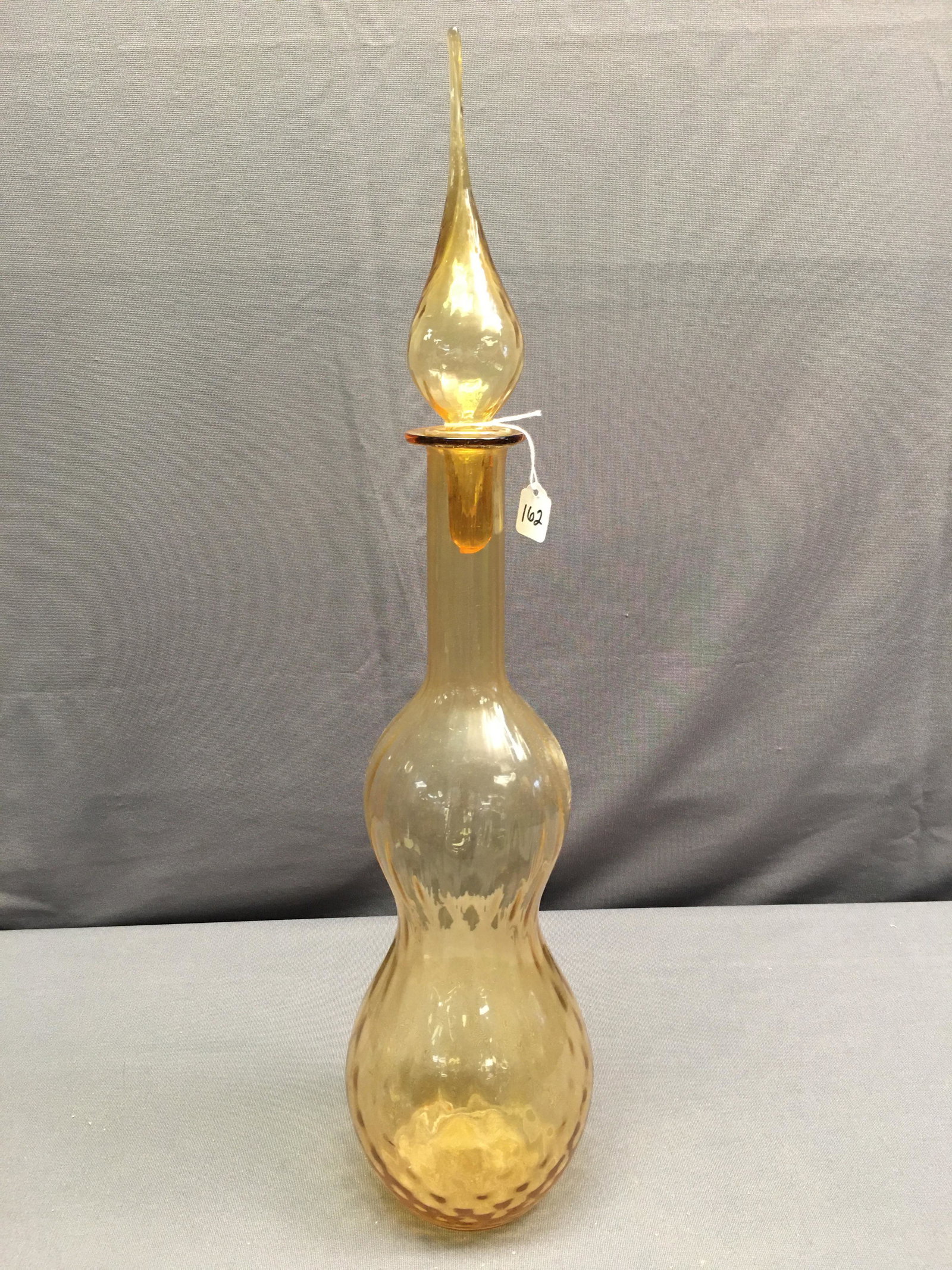 Empoli Style Glass Genie Bottle: MCM Empoli style glass genie bottle, amber/honey colored, teardrop stopper, needs stopper sleeve, 23.5"H x 5"W
