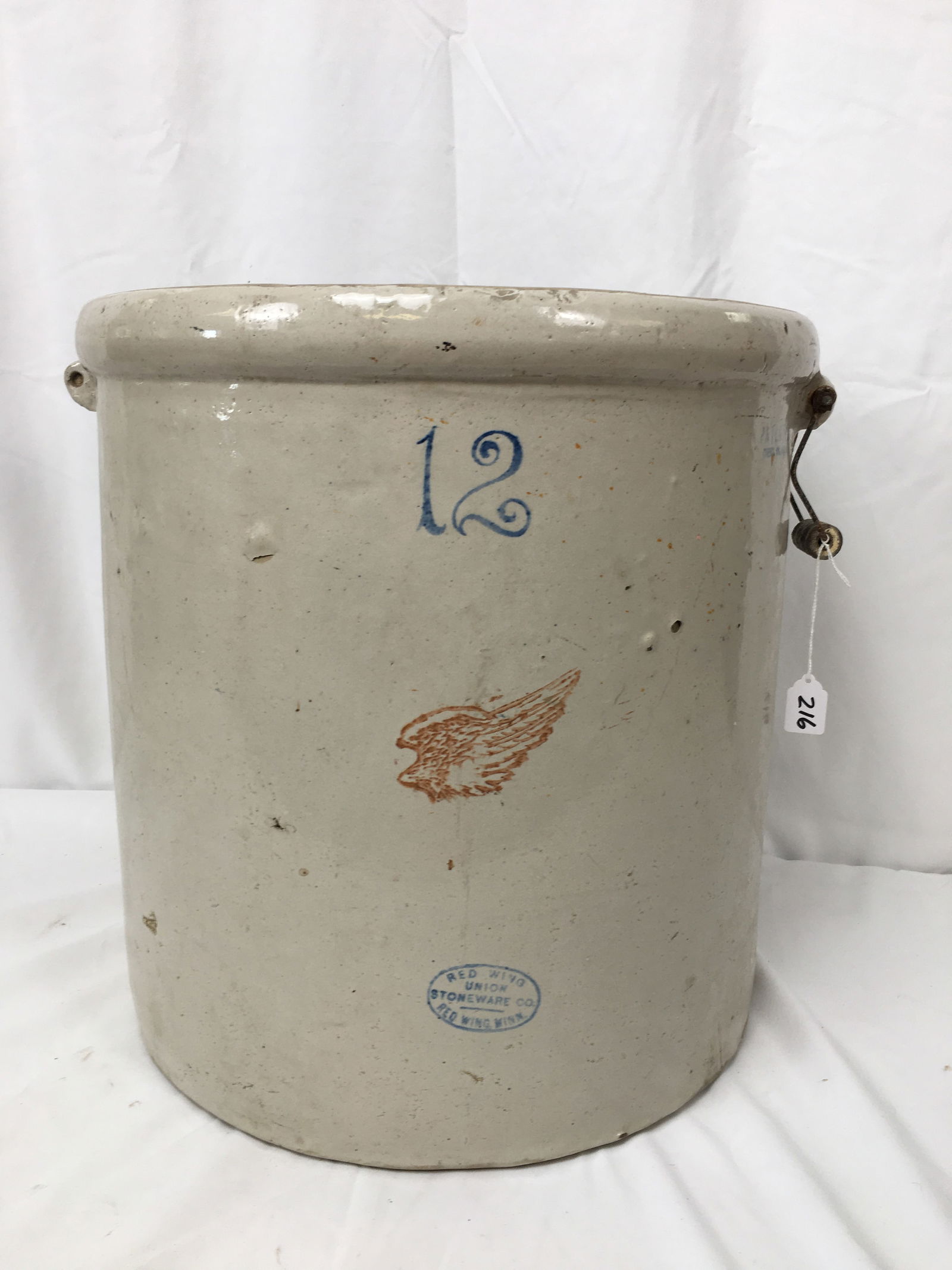 12 Gallon Red Wing Stoneware Crock: 12 Gallon Red Wing Stoneware Crock. With ski logo, Union Stoneware, Red Wing, Minn. One bail handle missing. Stamped Patented Dec. 21, 1915. 17"W x 17"H