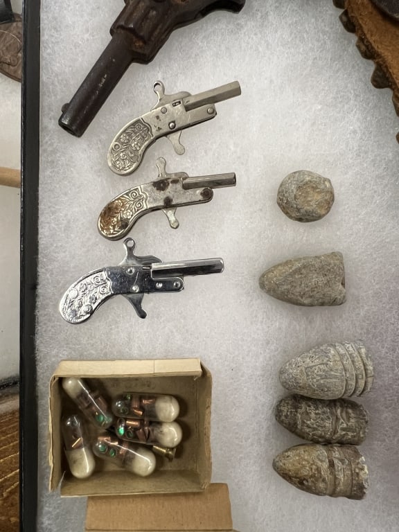 Civil War Bullets & Toy Guns: Group of 5 Civil War Bullets; 3 miniature cap guns w/caps in the box; cast iron Pluck toy gun in holster souvenir of Clifty Falls, Ind.; set of miniature tools made of Intercast, Kokomo, Ind