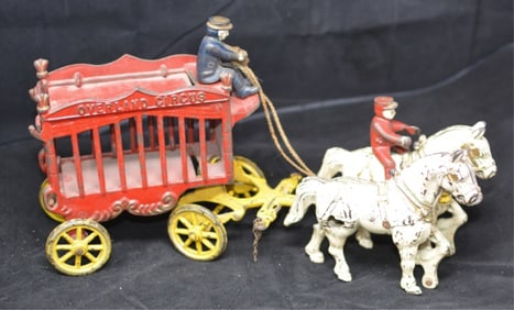 Cast Iron Toy Overland Circus Wagon has  driver and  rider 2 white horses, red cage  wagon on yellow