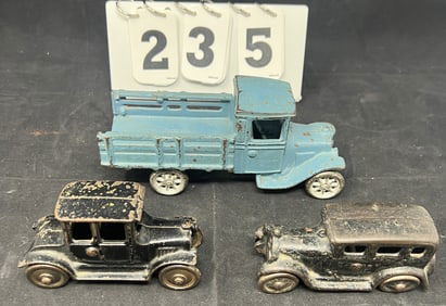 Three Cast Iron Arcade Toys : Blue stake bed   truck 3" x 7" x 3"  , two door sedan, 4 door   sedan.