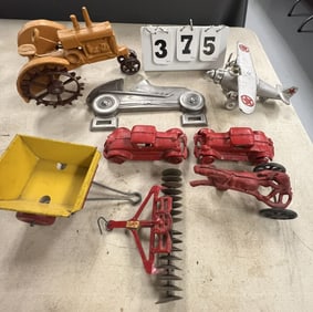 Flat of Cast Iron Toys: Airplane, 2 red  sedans,  tractor, sulky racer, a farm toy  disc & little