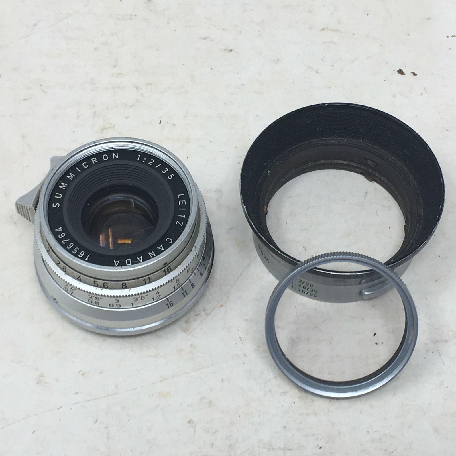 Leica Leitz Canada 1656764 Summicron 1:2/35 Lens: Leica Leitz Canada 1656764 Summicron 1:2/35 Lens. Incl. plastic case, IR00A Ernst Leitz Wetzlar Germany Hood, & E Leitz N.Y. SL filter. 2.25"H x 2.25"W with hood.