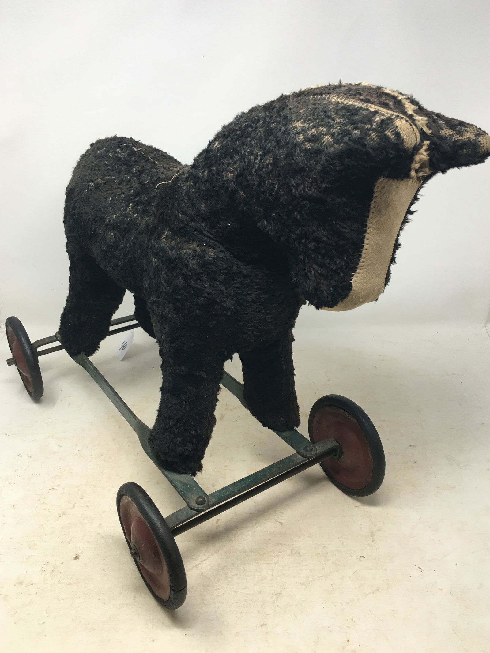 Antique Stuffed Horse Pull Toy: Antique Stuffed Horse Pull Toy. On wheeled metal platform. Neck is separated within fabric. Worn mane, losses to hide. 19"L x 9.5"W x 15"H