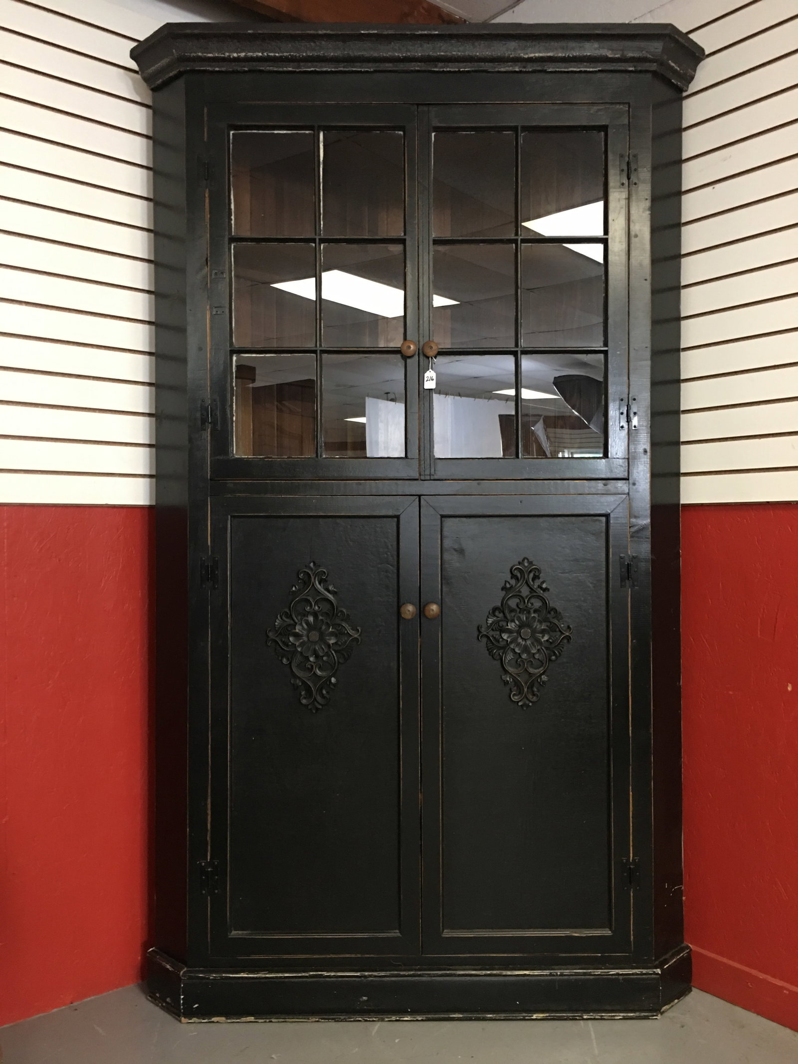 Black Corner Cupboard: One Piece Black Corner Cupboard. (2) 6-pane doors in upper, (2) blind doors in lower. Wooden knobs, baseboard & crown molding. 54"W x 24"D x 89"T