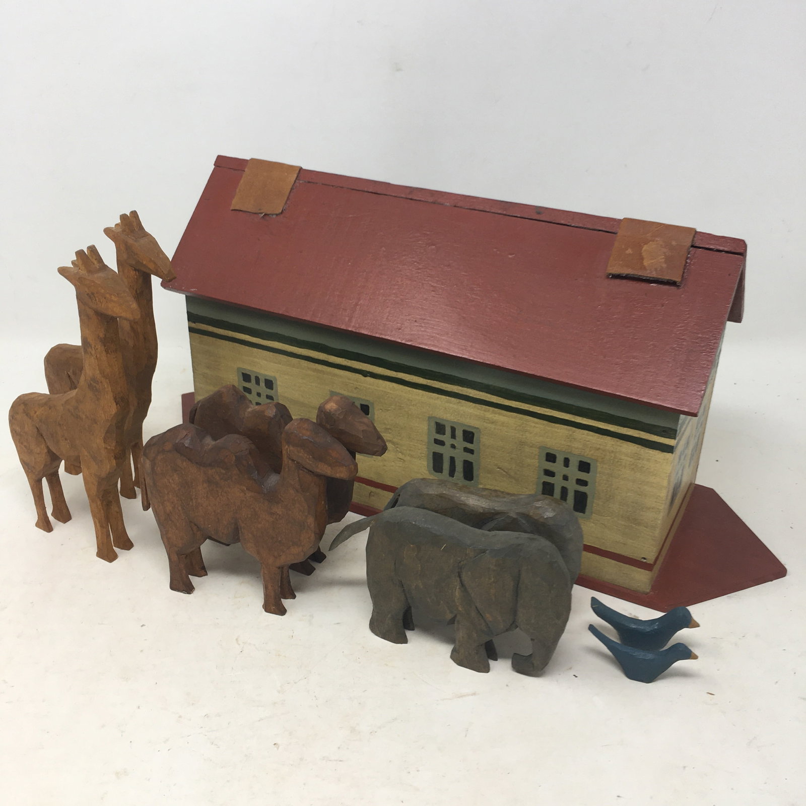 Folk Art Noah's Ark & Animals: Folk Art Noah's Ark. Painted ark with leather hinges. (8) Wooden Animals. (2) bluebirds, (2) camels, (2) giraffes, (2) elephants. 15"L x 4.5"W x 7"H