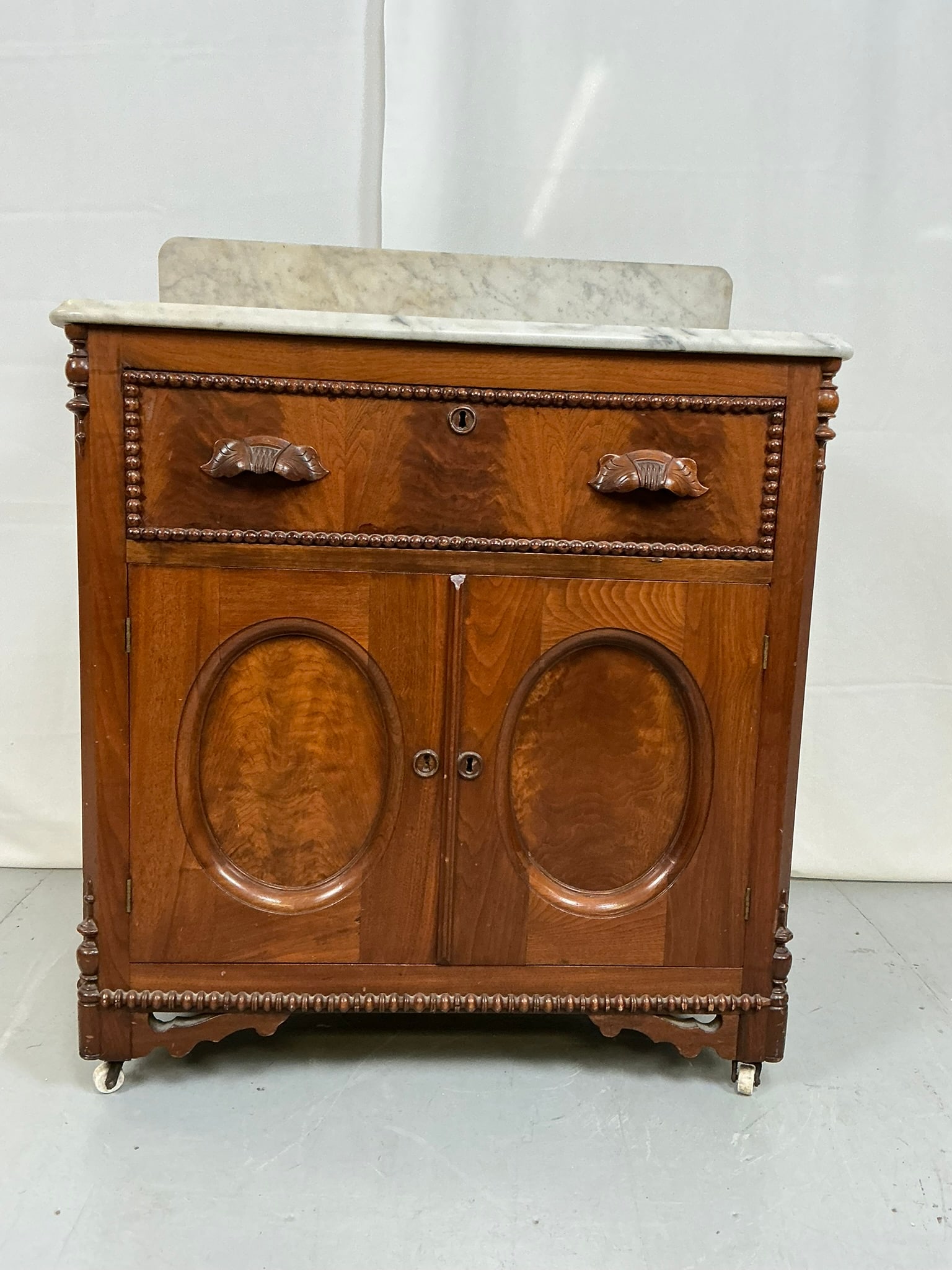 Marble Top Washstand: Two piece marble top washstand with decorative carved wooden pulls, 1 drawer & 2 doors. 29W"x 17"D x 35"T