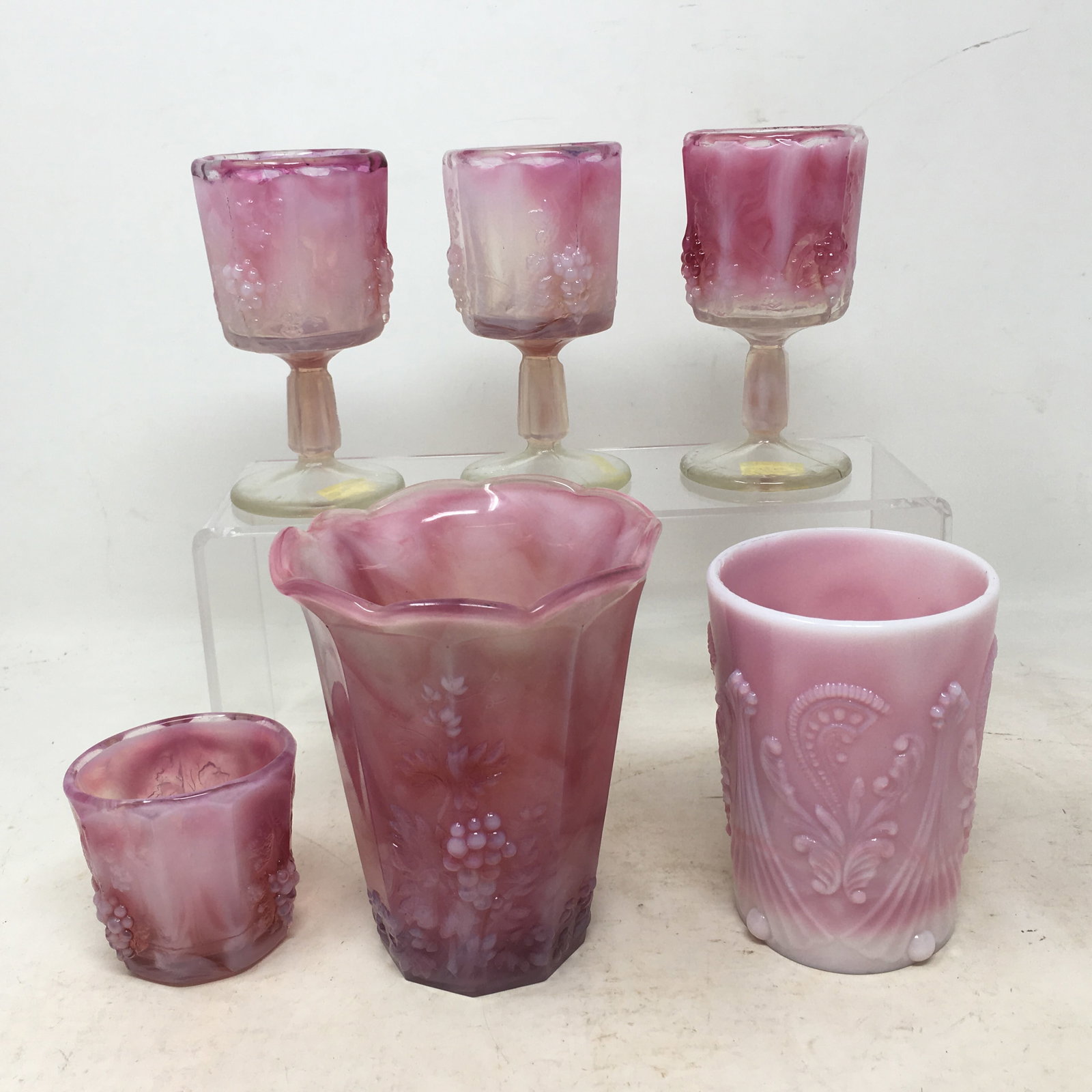 (6) Pieces St. Clair Pressed Glass, Pink Slag: (6) Pieces Pink Slag St. Clair Pressed Glass. 1) Flared fluted tumbler; 2) (3) wine glasses; 3) oval toothpick; 4) Inverted fan & feather water tumbler. All are grape & cable patterned except #4. All 