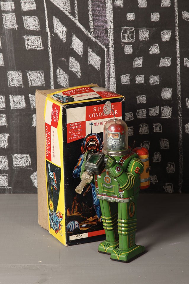 Japon Battery toy 1961 Daiya - Cragstan: Space conquerorBoite reeditionH. 32 cmBibliographie : Yukio Shimizu, Teruhisa Kitahara Robots. Spaceships and other Tin Toys, Taschen, illustre p. 26Tin litho battery operated Space Conqueror with rei