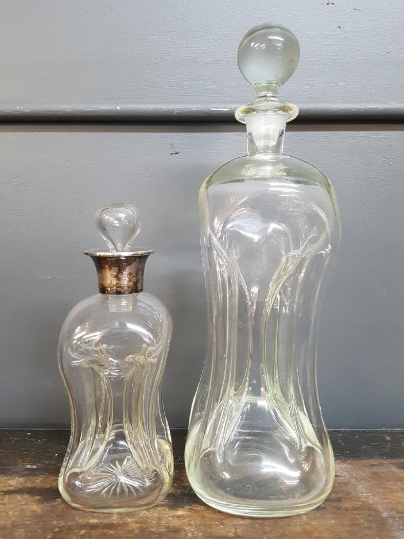 Pair of MCM Pinched Glass Decanters, Silver: Pair of Mid Century Scandinavian Pinched Glass Decanters with stoppers, One with hallmarked silver collar, Holmegaard small 9" tall 14"