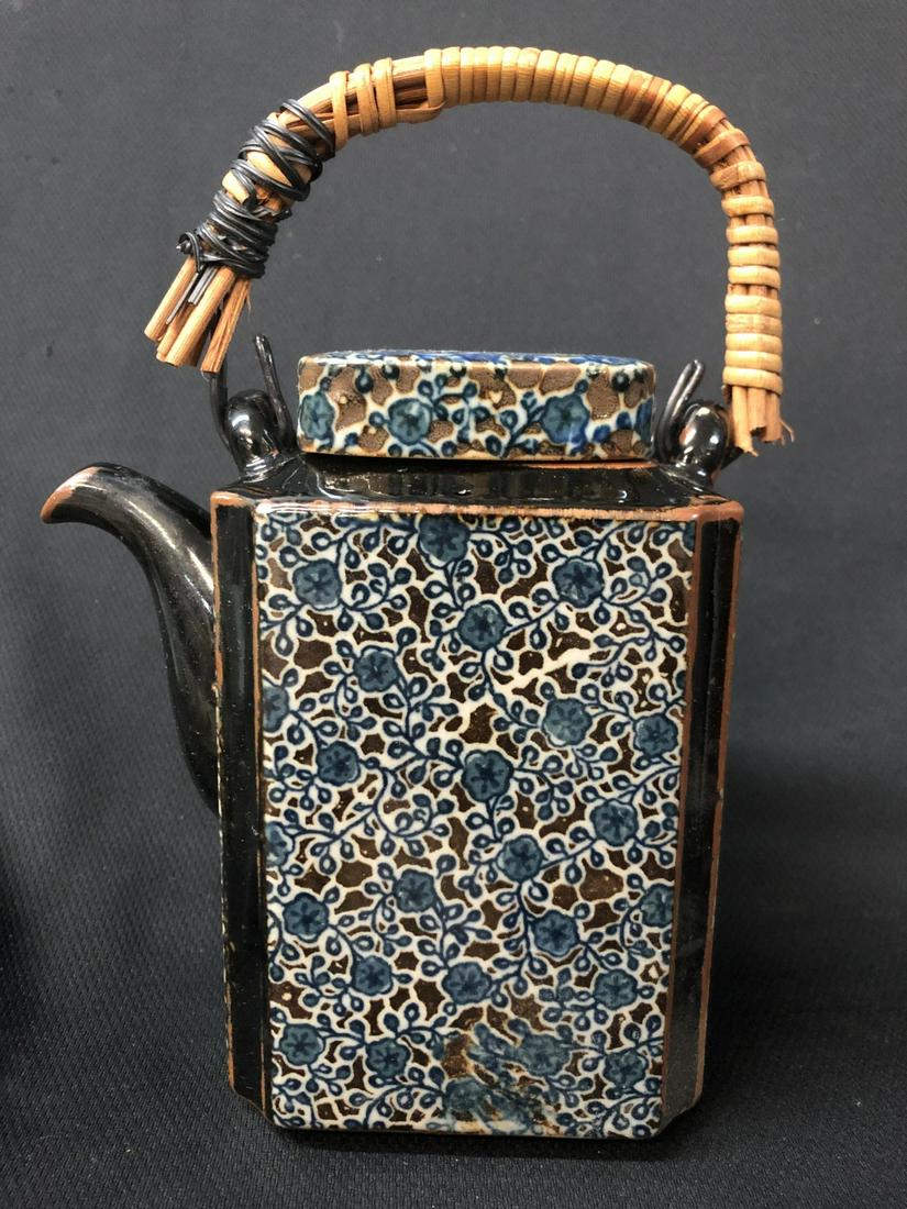 Black Floral Chinese Teapot With Wicker Handle: Black Floral Chinese Teapot With Wicker Handle, Unmarked. Needs Repair To Wicker Handle. 8.5 Inches High.