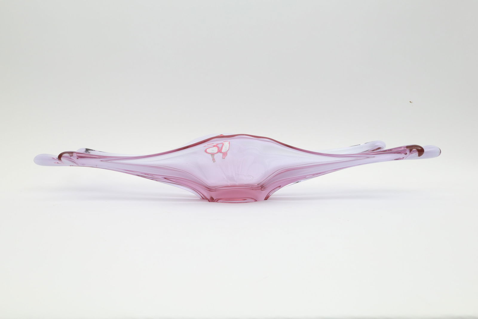 Val St Lambert Freeform Alexandrite Neodymium Bowl: Handblown free form design in Alexandrite neodymium glass that shades from pink to blue depending on the light, with original paper label, 1950s. 25 inches L x 8 W x 4 H.