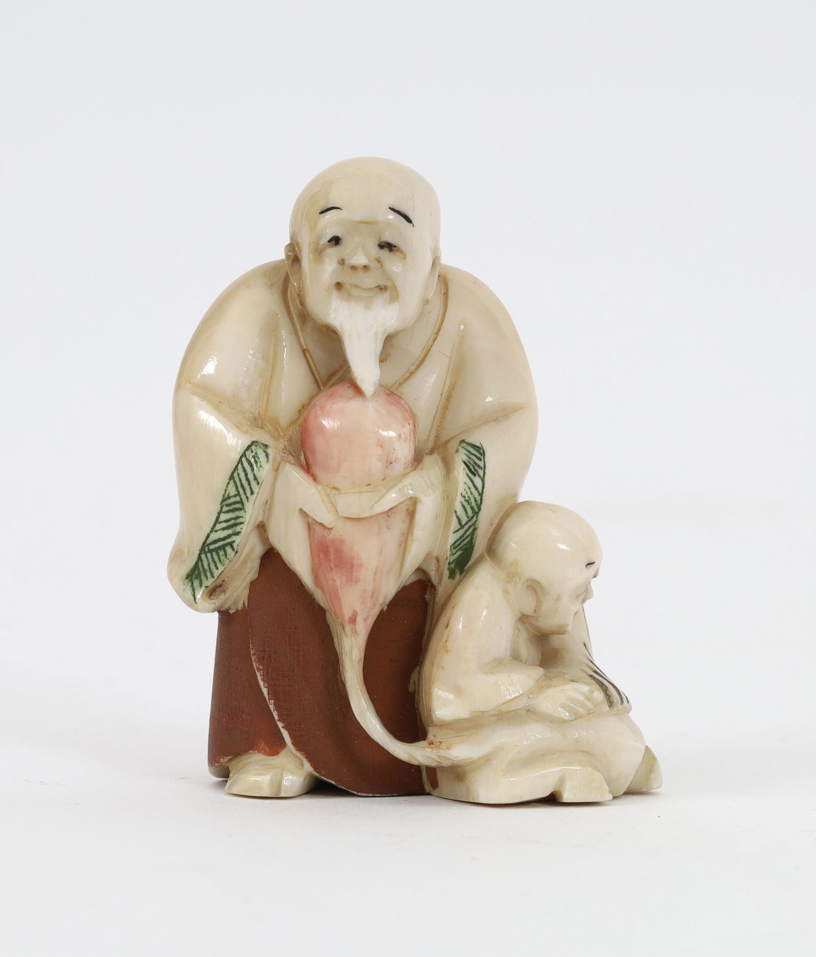 Japanese Netsuke Wise Man Holding Gourd Signed: Japanese handcarved netsuke of a wise man holding a gourd with another smaller older man crouched down by his side, with hand engraved and painted details, signed. 2 inches. This item cannot be export