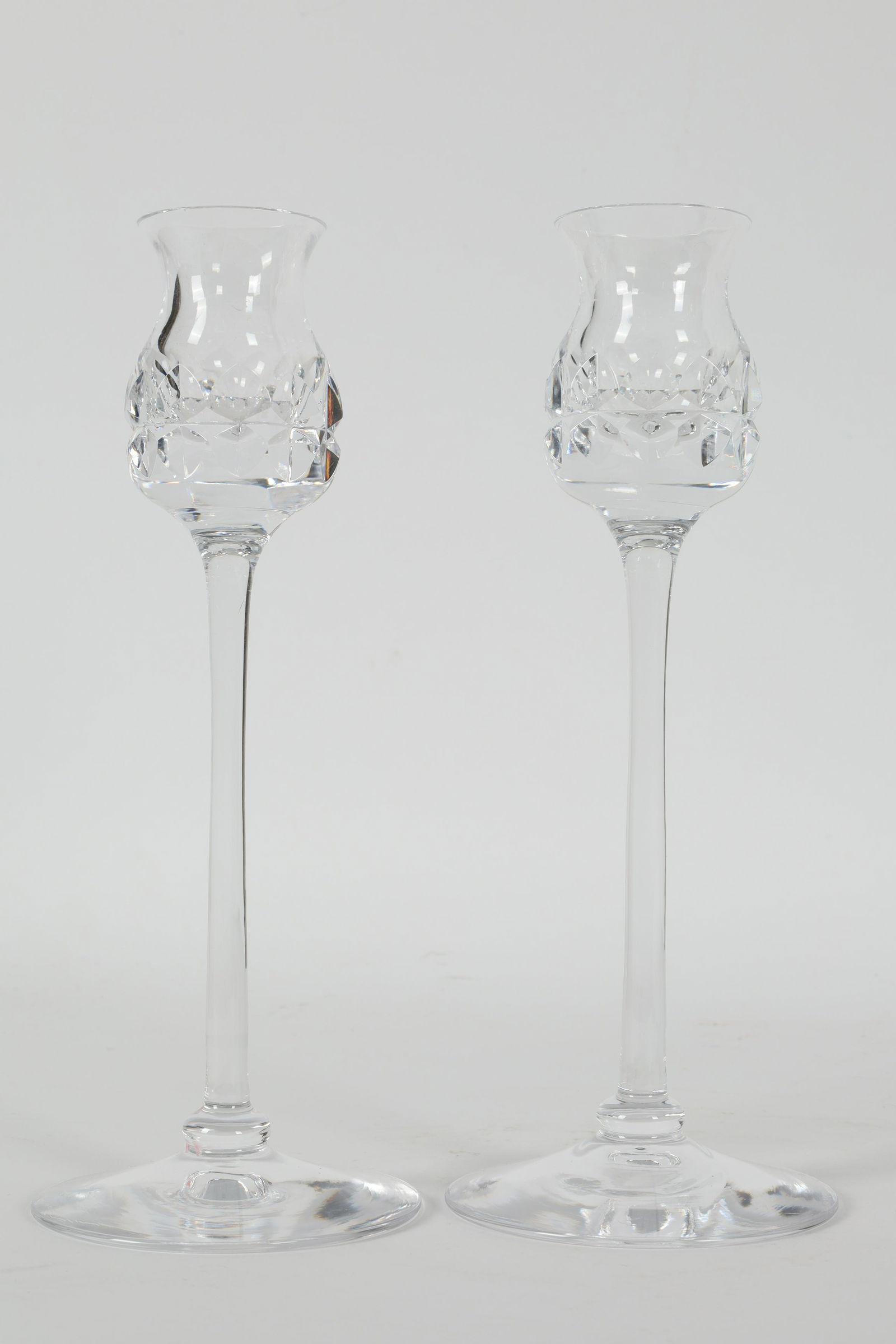 Kosta Boda Sweden Goran Warff Glass Candlesticks: Kosta Boda of Sweden hand blown tall art glass candlesticks with Geometric hand cut pattern around the bowl of candle holder, marked on base Kosta 66201 Warff. 9 inches H.