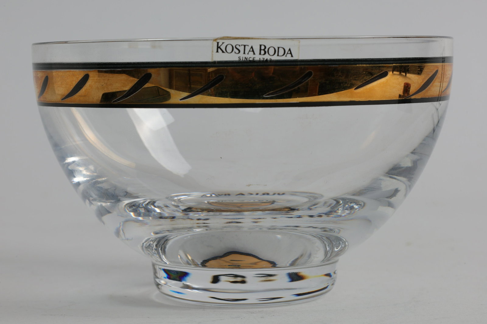 Rare Signed Kosta Boda Ulrica Hydman-Vallien Bowl: Rare Signed Kosta Boda Ulrica Hydman-Vallien Bowl. Gilt decoration around rim and stylized cat face in bottom of bowl. Signed in paint and etched around bottom of bowl. Measures 4.75 inches x 3 H.