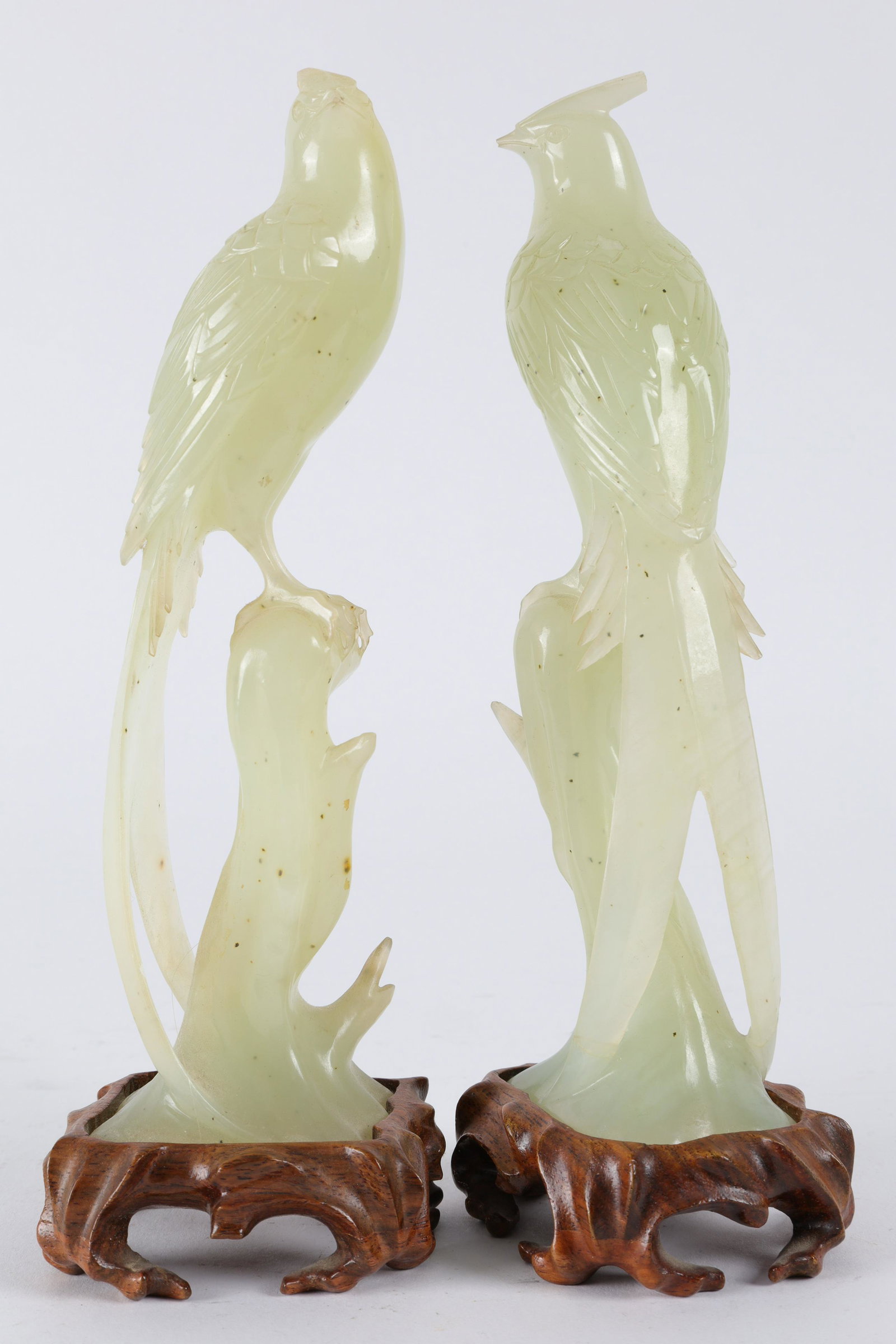 Pair of Chinese Carved Green Hard Stone Birds: Pair of Chinese Carved Green Hard Stone Birds of Paradise. On wood carved stands. Measuring 8 inches H x 2.5 x 2.25 deep including stands. Small areas of loss near the tail feathers, head feathers, pl