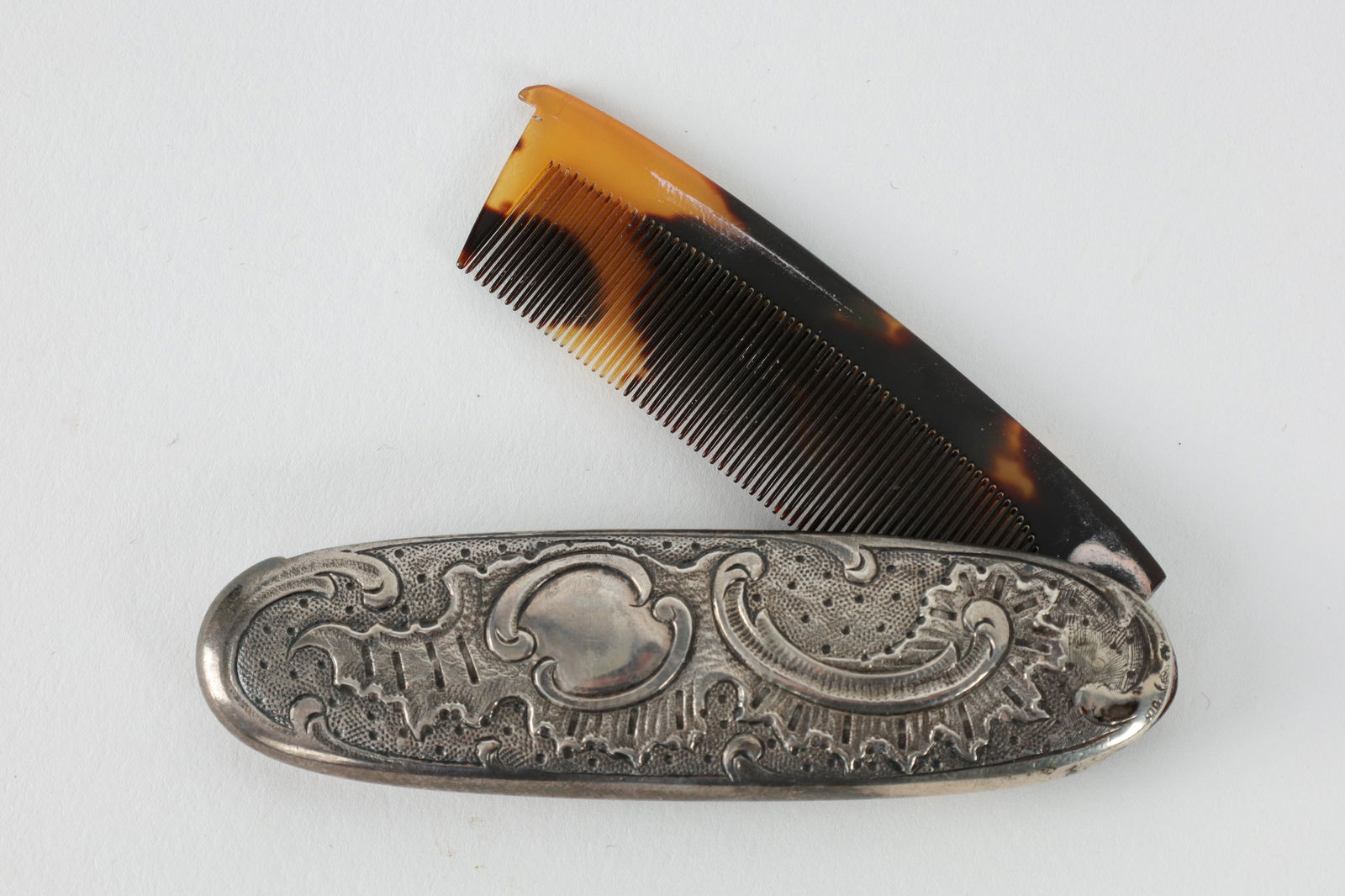 Antique German Silver Tortoise Shell Comb: Antique German Silver Hinged Tortoise Shell Fine Tooth Comb. Measures 3.25 inches L x 1 W in closed position. Provenance: From the Collection of Marie-Claude Groenendaal-Ruf
