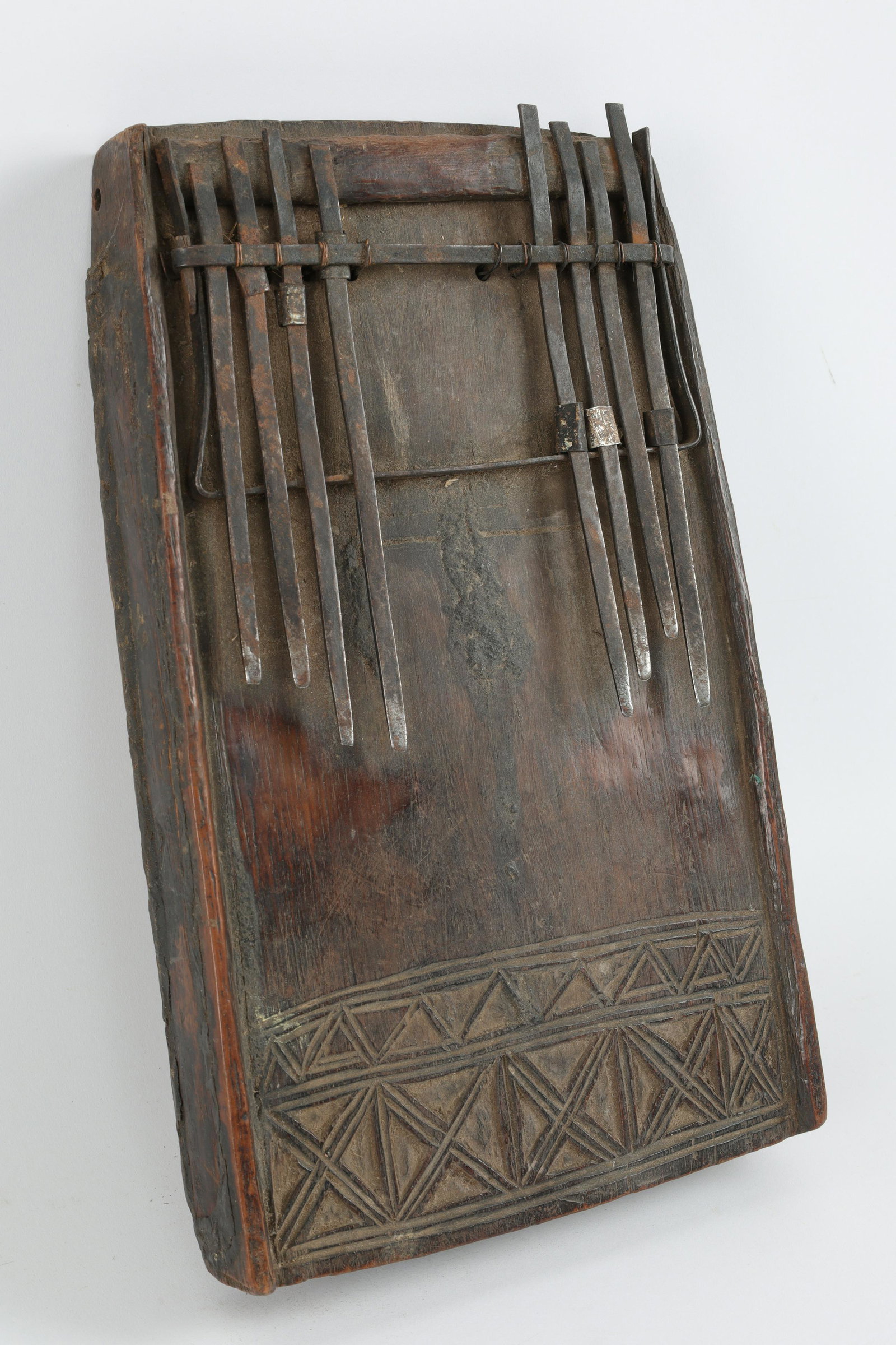 African Chokwe Lamellophone: African Chokwe Lamellophone. Measures 12 inches L x 7 W x 2 deep. Carved geometric pattern with coins inside.
