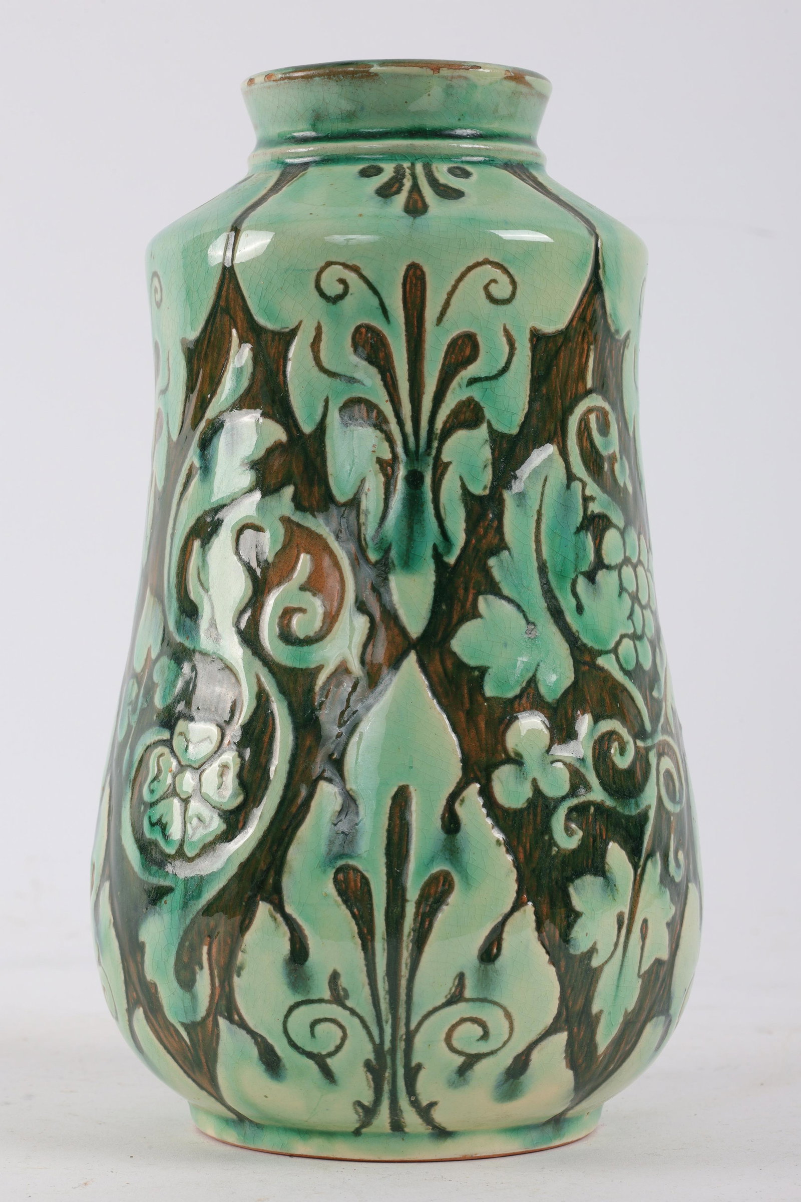 1900 Della Robbia Arts and Crafts Vase Ruth Bare: C. 1900 Della Robbia Arts and Crafts Vase by Ruth Bare. Green stylized foliage on a dark green background. Signed on base DRC around ship with initials RB, model number 602. 8 inches H x 4 W.