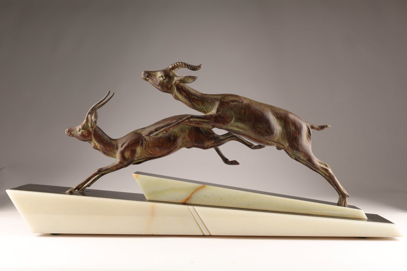 Art Deco Spelter Sculpture Two Leaping Impalas: Art Deco Spelter Sculpture Two Leaping Impalas On Onyx and Black Slate. Some small chips to base, restoration to one hind leg. 26 L x 4 W x 12 inches H.