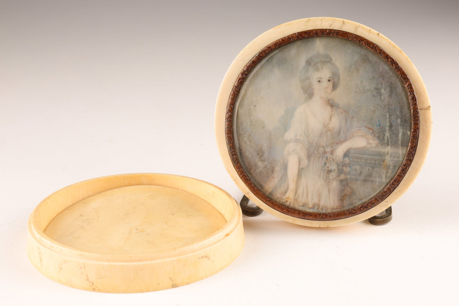19th C French Pill Box Painted Portrait Young Lady: 19th C French Pill Box Painted Portrait of Young Woman. Box has some condition issues. Needs to be re-glued. Please see photos. This item cannot be exported from Canada. 3.5 inches diameter x 1.25 H.