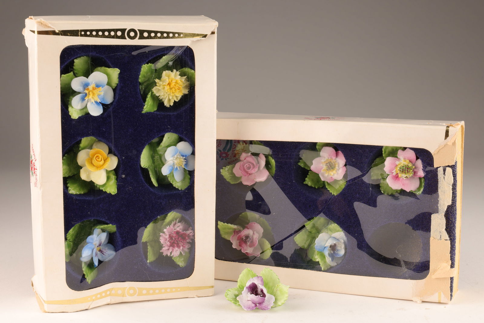 Set Royal Adderley China Floral Place Card Holders: Set of 12 Royal Adderley English bone china place card holders in the form of flowers with foliage, all 12 are different, signed on base Royal Adderley Floral Bone China England. Boxes measure 7 x 4.2