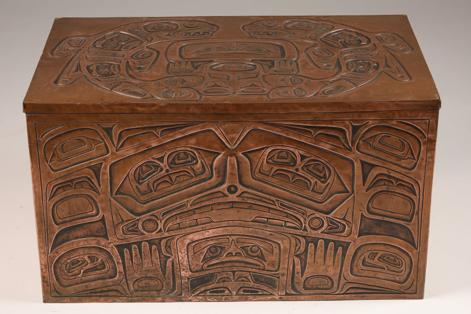 NW Coast Haida Whale People Copper Clad Trunk: Northwest Coast Large copper clad wood trunk, the copper with hand chased Haida totemic designs on the lid, front and sides showing whales, eagles, bears and faces, the Haida or Whale People originate