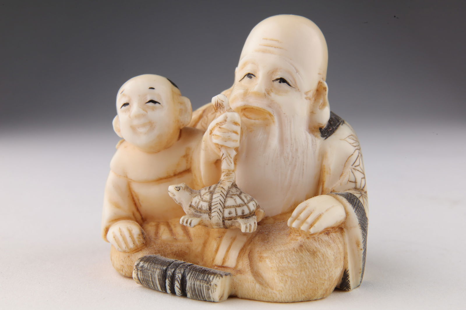 Signed Japanese Netsuke Old Man, Child And Turtle: Signed Japanese Netsuke Of An Old Man, Child And Turtle. 2 inches H. This item cannot be exported from Canada.