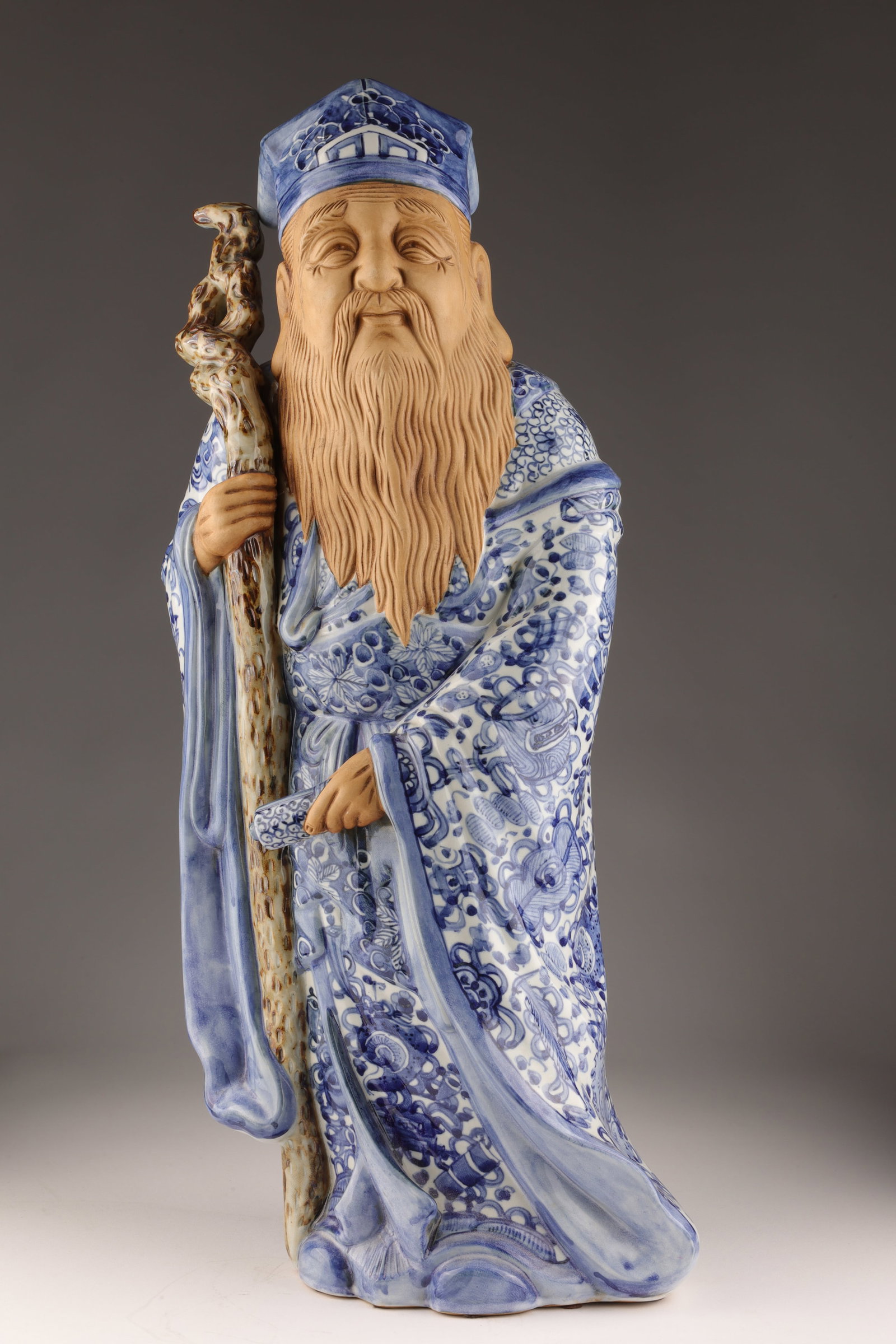 Signed Japanese Porcelain Figure Immortal Jurojin: Signed Japanese Porcelain Figure of an Immortal Jurojin in blue and white robes with staff and scroll. 22 inches H.