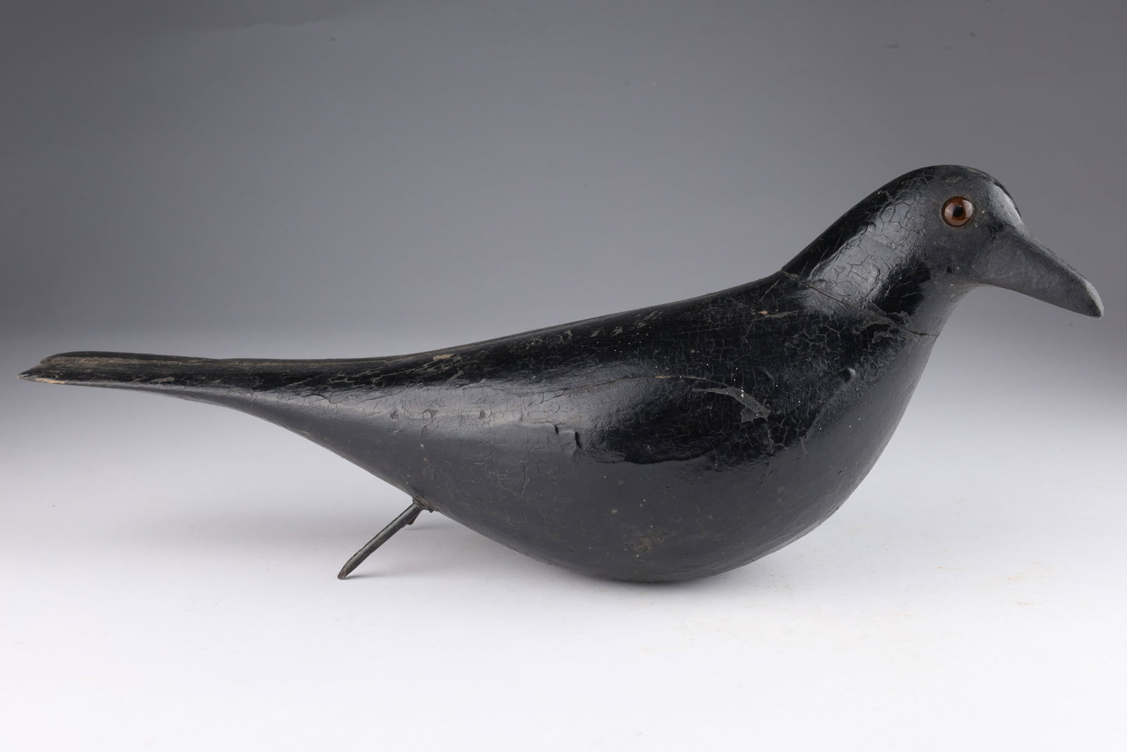 Folk Art Hollow Crow Decoy by Charles Perdew: Folk Art Carved Hollow Crow Decoy With Glass Eyes by Charles Perdew. 15 inches L x 3.5 W. Separation to wood, repair to bill. Please see photos.