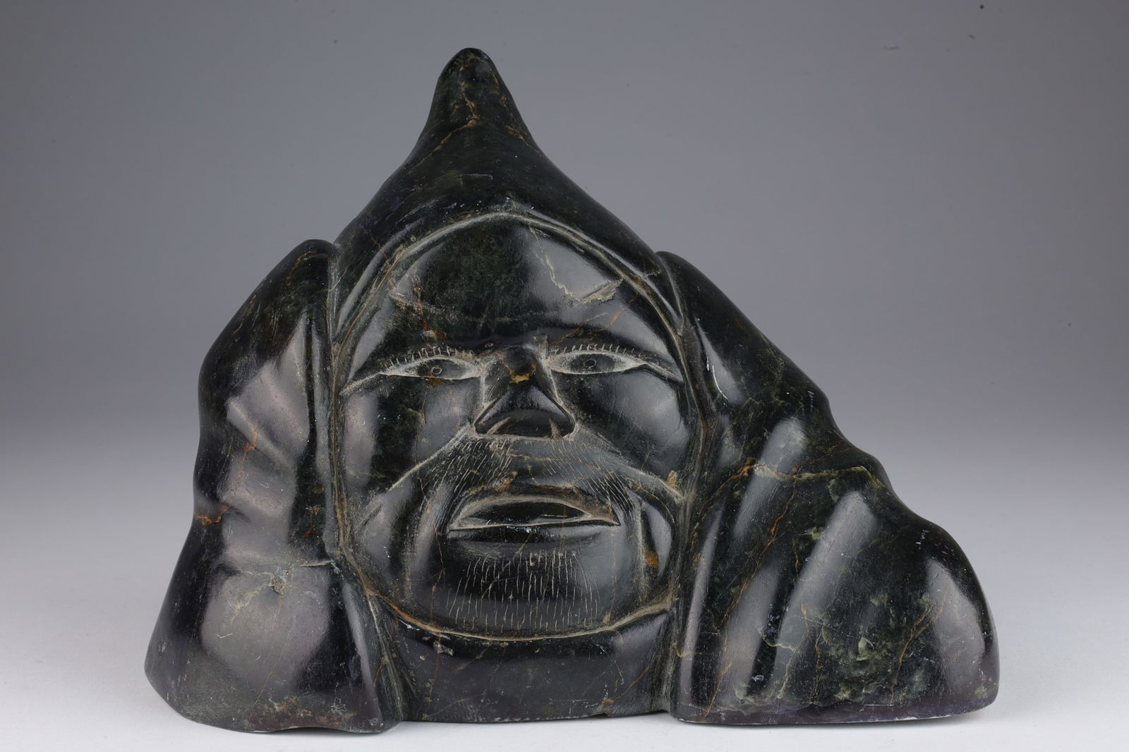 Signed 1950s Inuit Soapstone Carving Man Head: Signed 1950s Inuit Soapstone Carving of a Mans Head. Signed Ipak (?) on base. 7 inches W x 5.75 H x 3 deep.