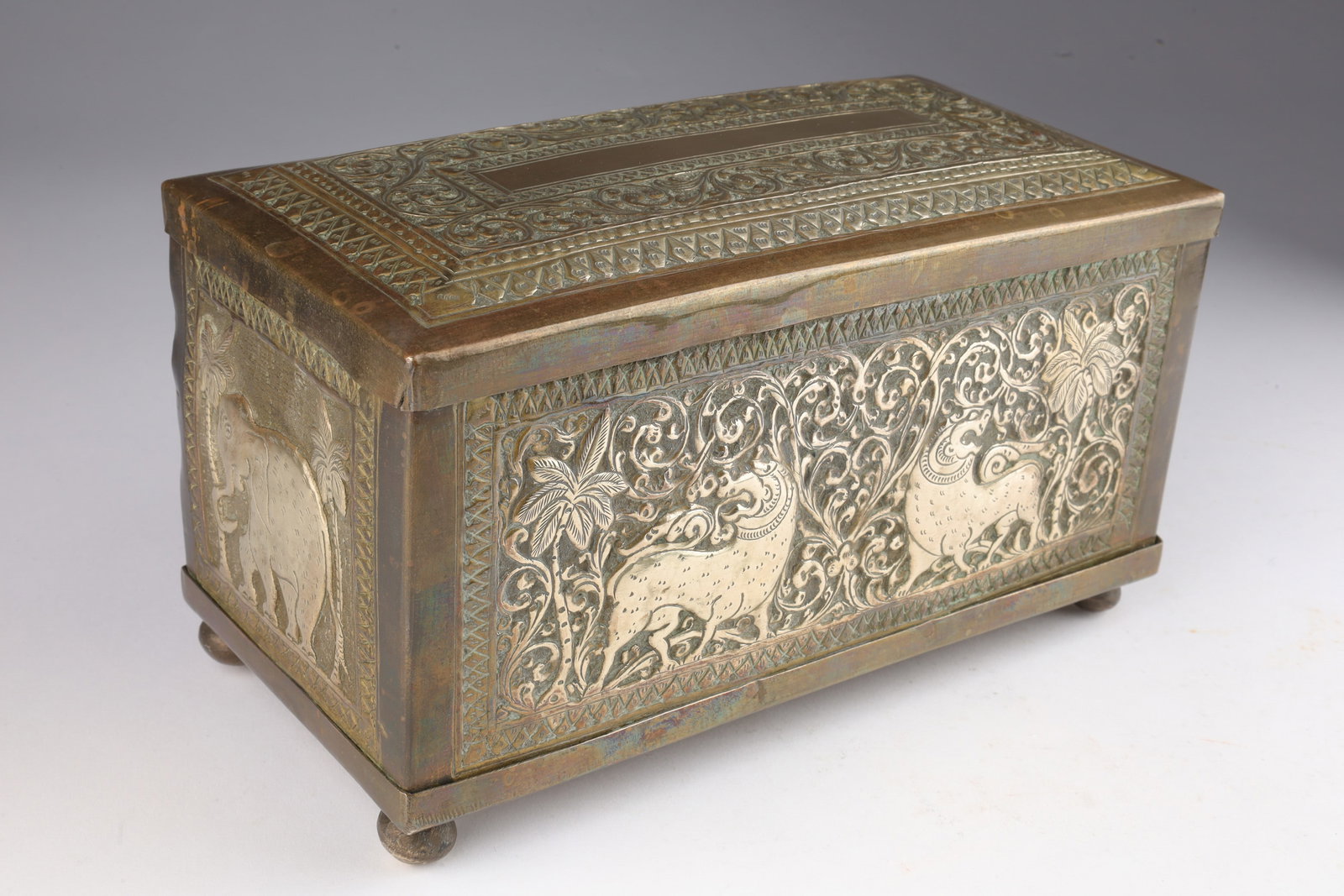 Antique Indian Bronze Embossed Trinket Tea Box: Antique Indian Bronze Brass Embossed Betel Nut / Trinket Box. 8 inches L x 4 W x 4.5 H. Decorated with beasts and elephants amid circular scroll pattern. Small dents to side. Please see photos.