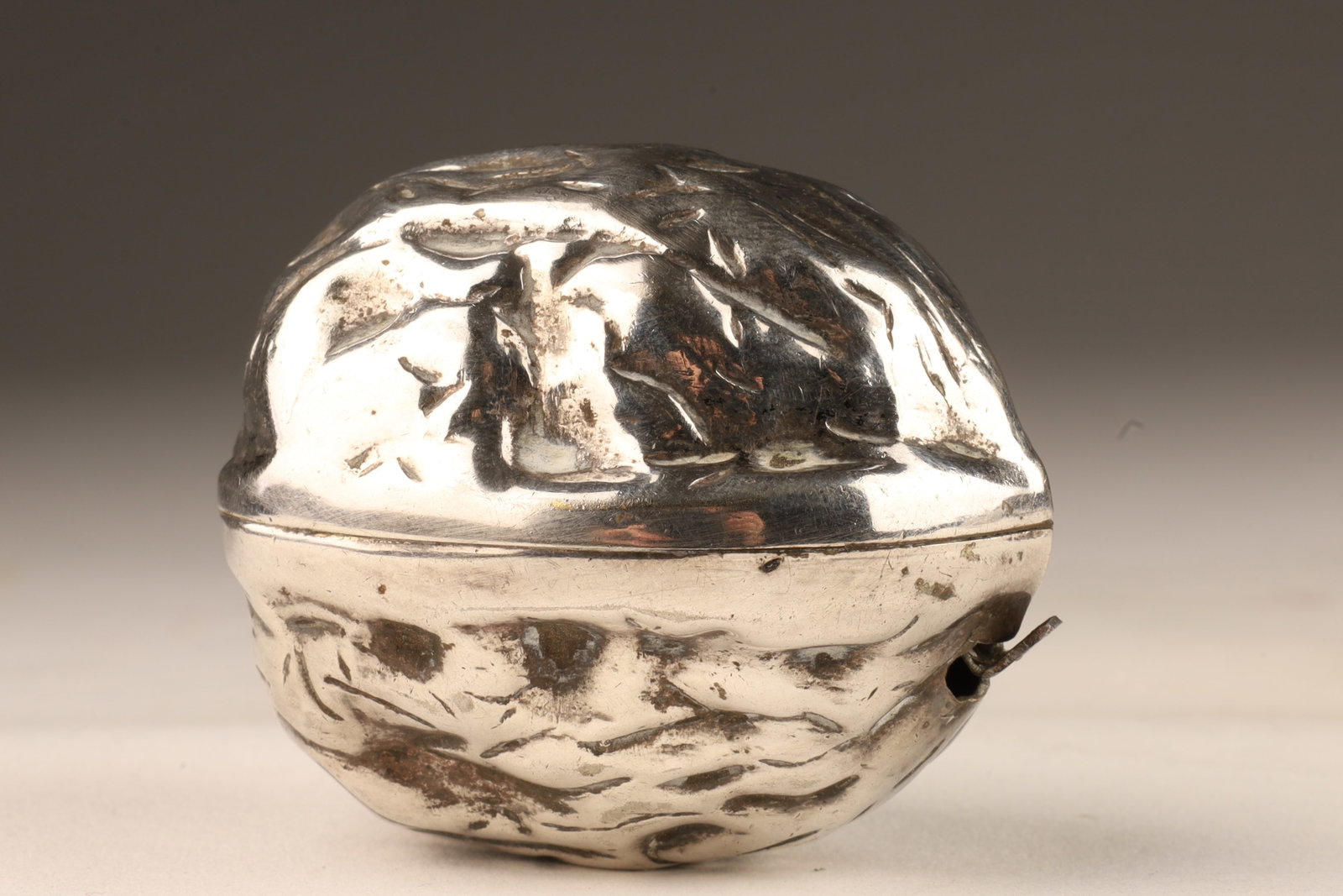 Silver Plated Walnut Form Tape Measure: Silver Plated Walnut Form Tape Measure. 2 inches L. Tape extends approximately 100 cm.