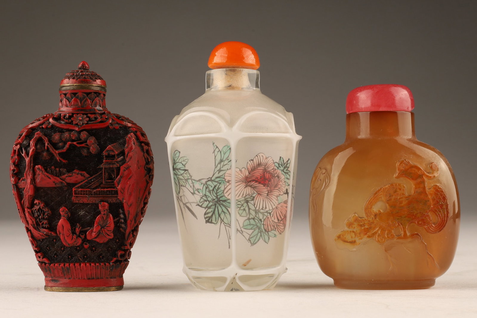 Lot Antique Chinese Snuff Bottles: Lot Antique Chinese Snuff Bottles. Agate bottle with carved Hoho bird (spoon currently stuck, pink top has a chip), cinnabar bottle signed, reverse painted faceted cameo grass bottle with flowers. All