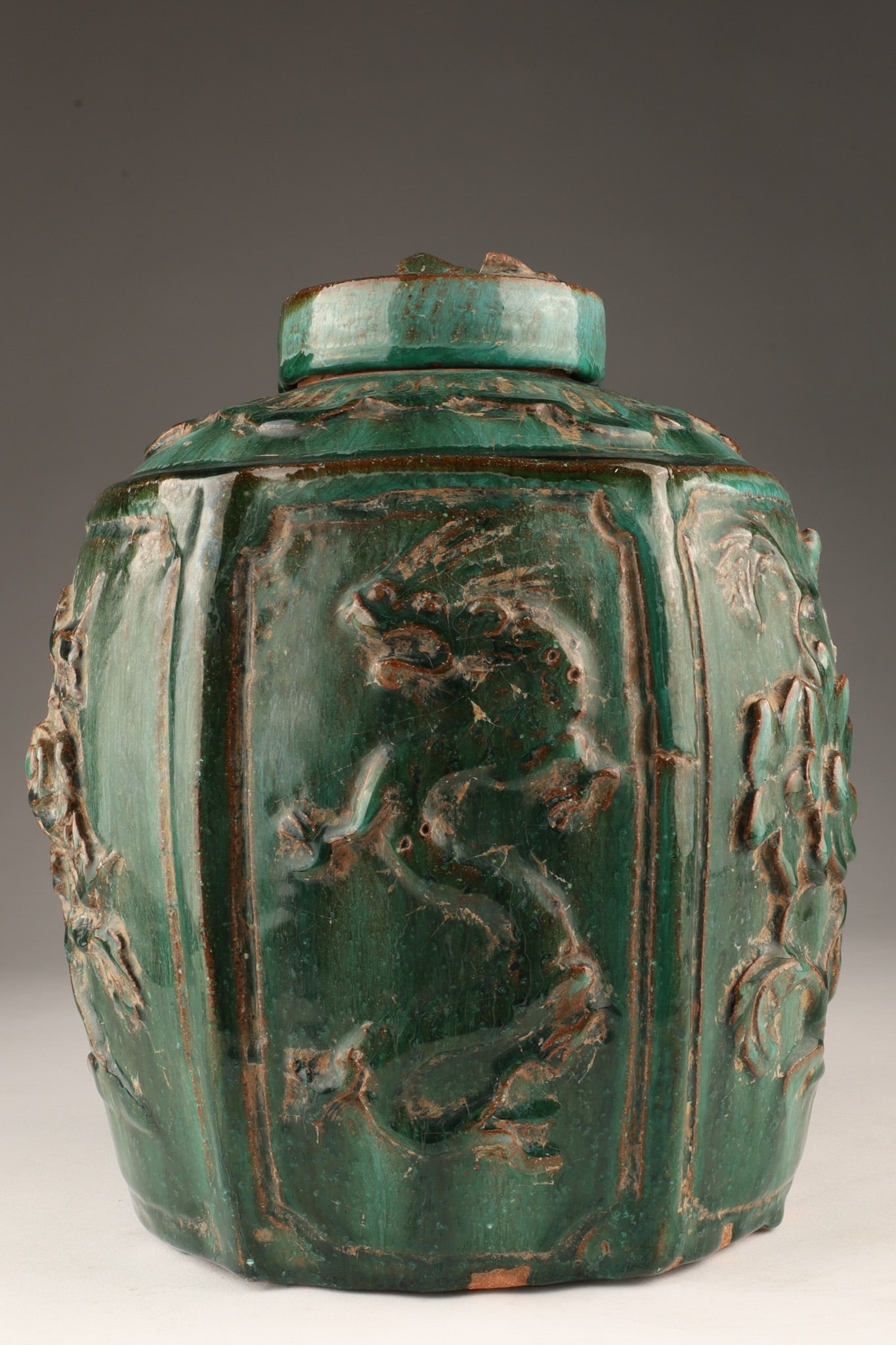 Large Antique Chinese Green Glaze Ginger Jar: Large Antique Chinese Green Glaze Ginger Jar. Some small chips to raised animals and flowers in panels. 10 inches H.