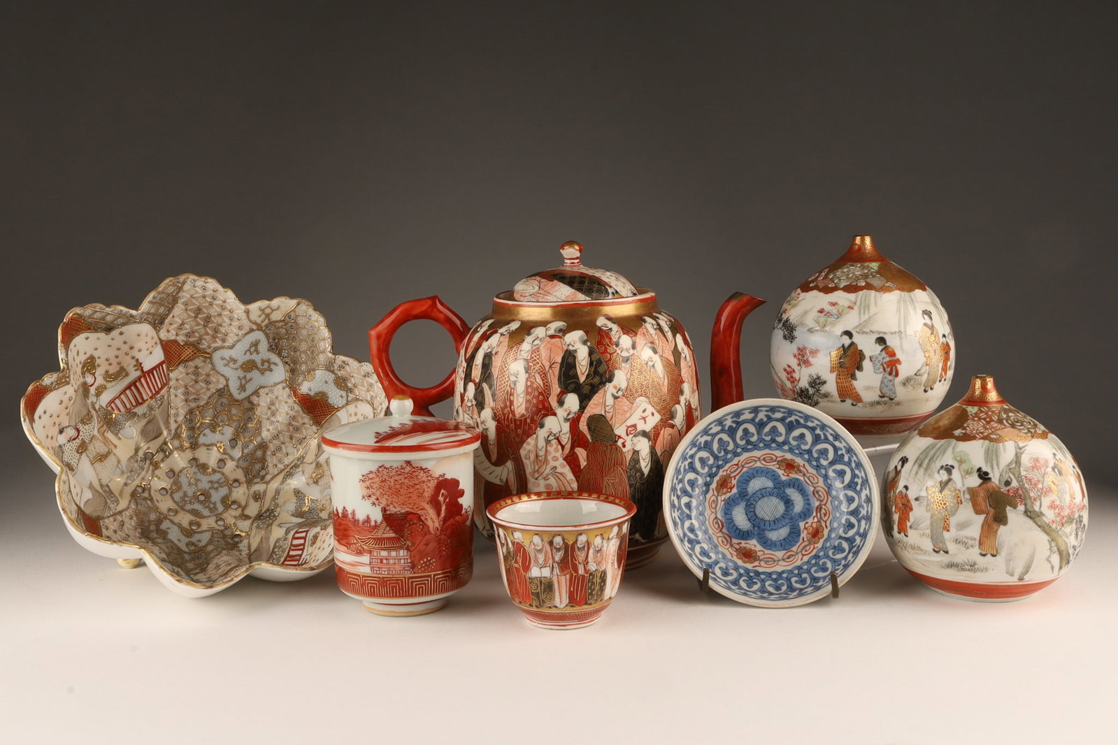 Lot of Japanese Kutani Porcelain Items: Lot of Japanese Kutani Porcelain. Two water droppers measuring 4 inches H, teapot measures 6.5 inches H x 7 W (restoration to teapot), moriage fluted bowl (strainer) measures 3.5 inches H x 7 W.