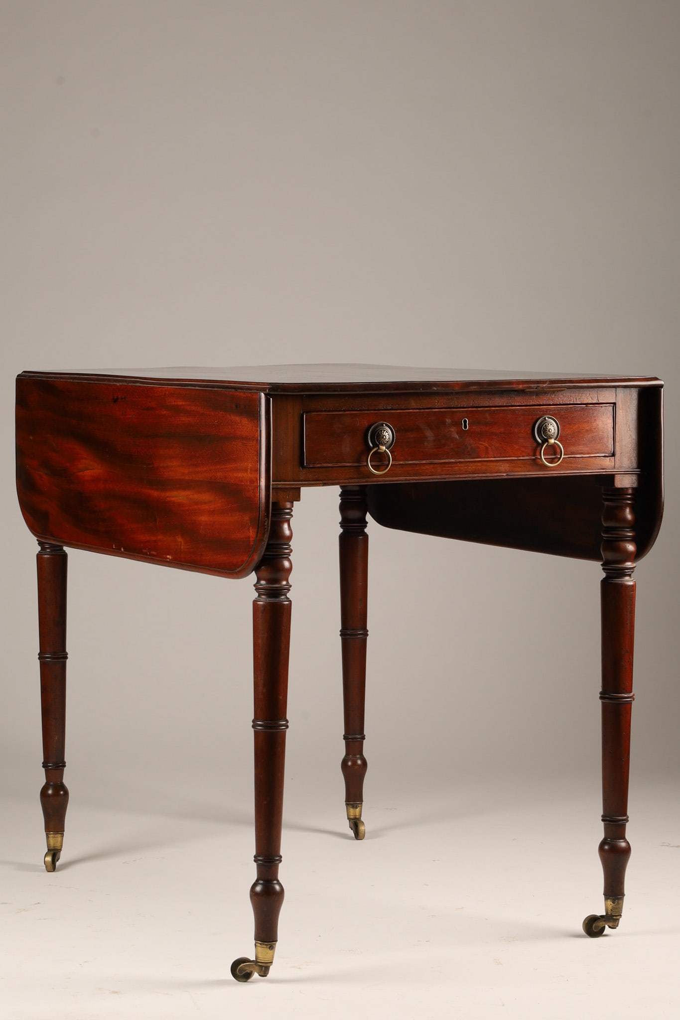 19th C Regency Mahogany Drop-Leaf Pembroke Table: 19th C English Regency Mahogany Drop-Leaf Pembroke Table, original brass handles and castors. The drop down sides are each supported by two pull out supports, and the single drawer is divided inside a