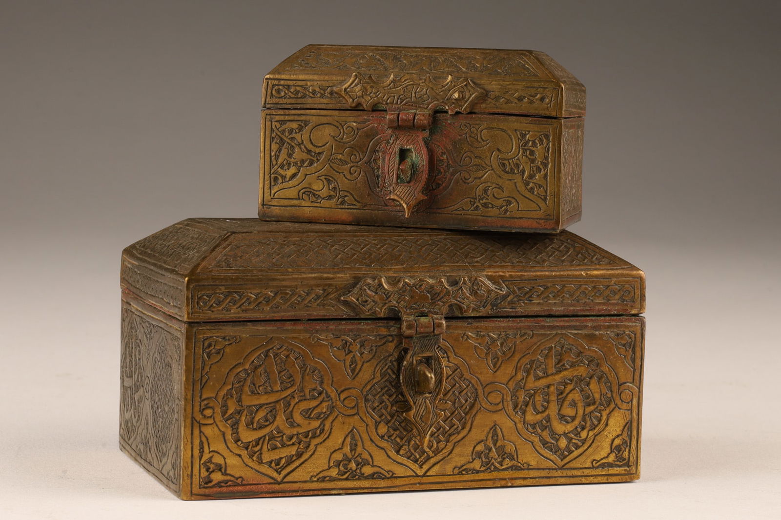 Small Antique Middle Eastern Brass Casket Boxes: Lot of 2 Small Antique Middle Eastern Brass Casket Covered Boxes. Decorated with script, larger measures 4 inches W x 2.5 deep x 2 H, smaller measures 2.5 L x 1.75 deep x 1.5 inches H.