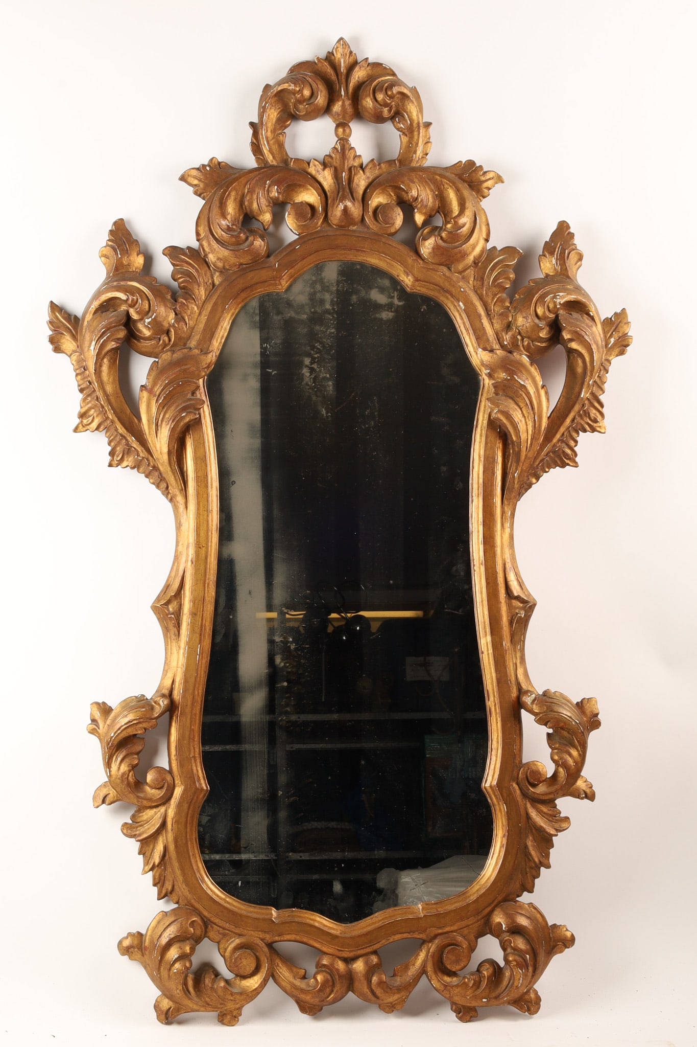 Large Antique Shaped Rococo Gilt Wall Mirror: Large Antique Shaped Rococo Style Gilt Wall Mirror. Carved wood with gesso and gilt finish, minor loss to finish. Measures 53 inches H x 32 W.
