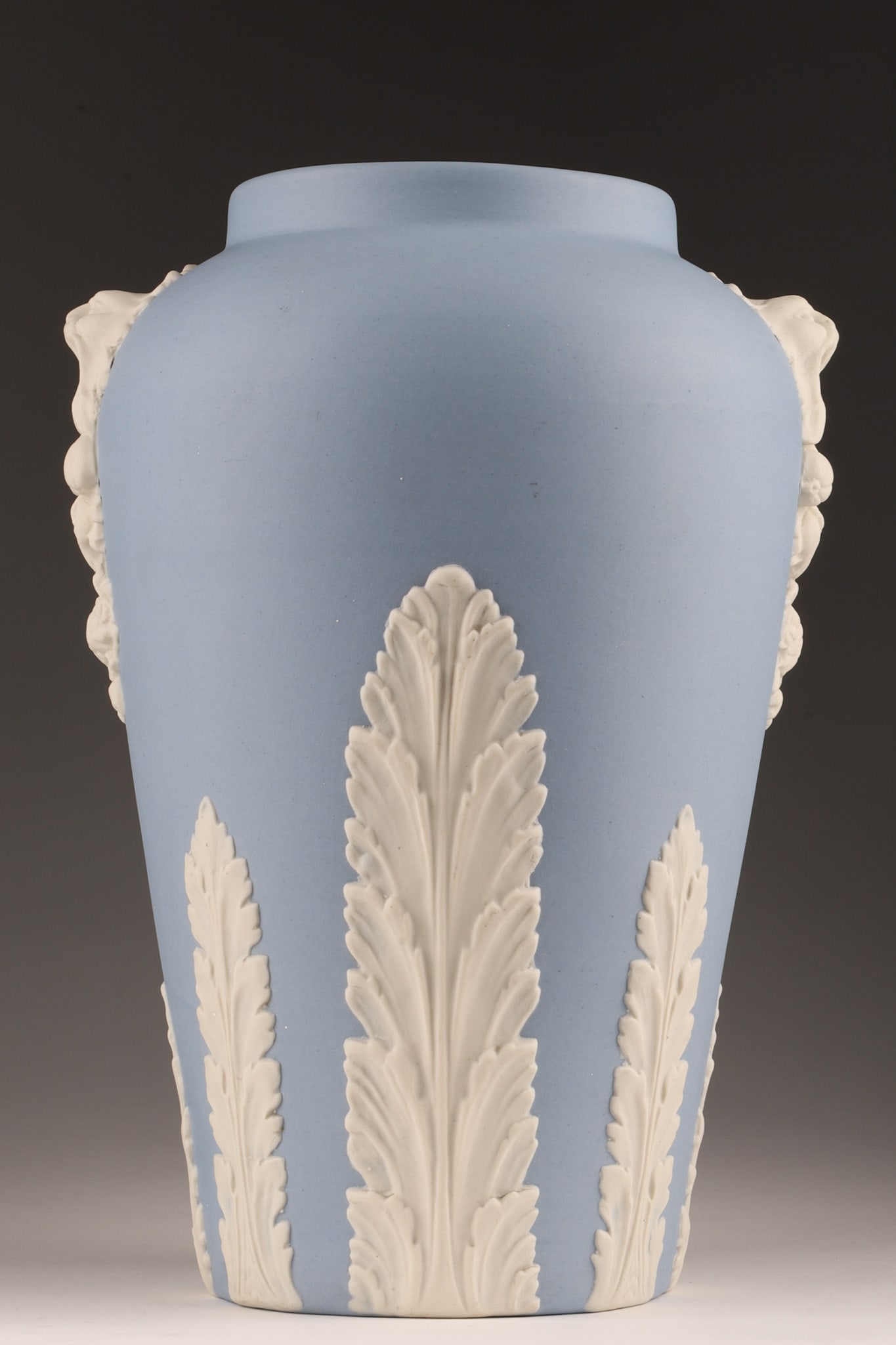 C. 1930s Ecanada Jasperware Vase With Lion Masks: C. 1930s Ecanada Jasperware Pale Blue Vase With White Lion Masks. 10 inches H x 7 W. Marked on base.