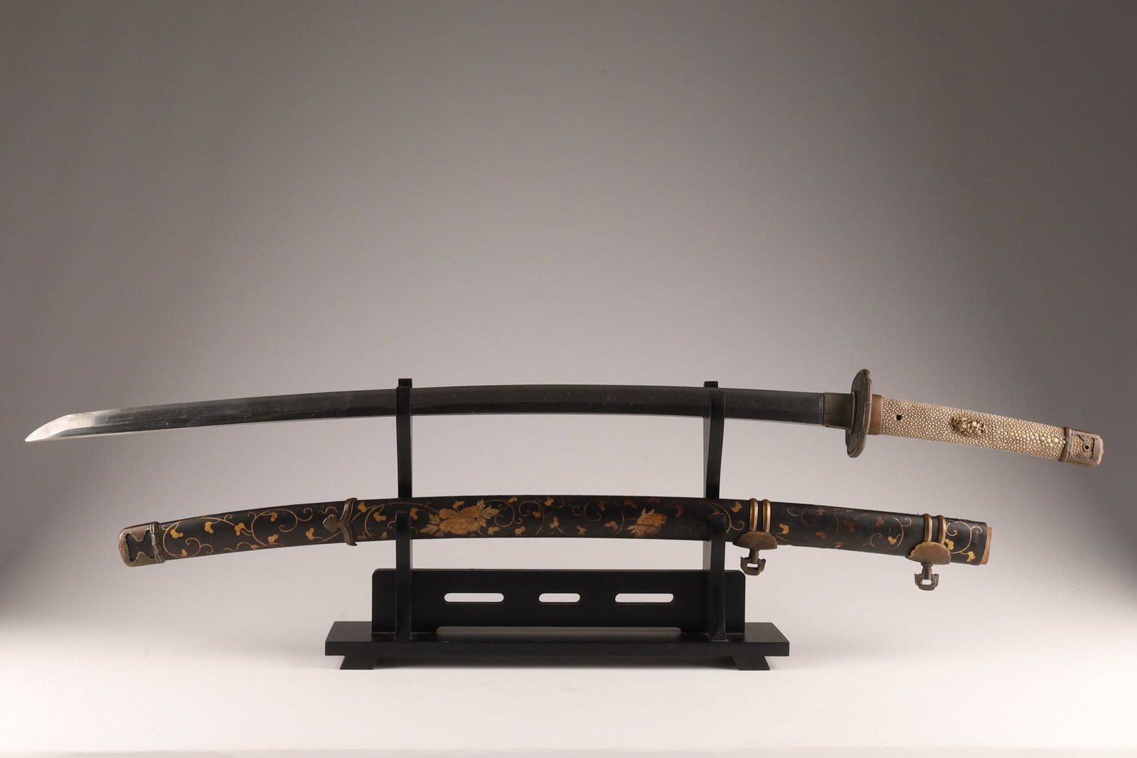 Antique Japanese Tachi Samurai Sword: Antique Japanese Tachi Samurai Sword, mumei, with Rayskin Handle and Gilt scrolling floral pattern, Gilt bronze menuki. Sword measures 39 inches L, blade measures 28 inches.
