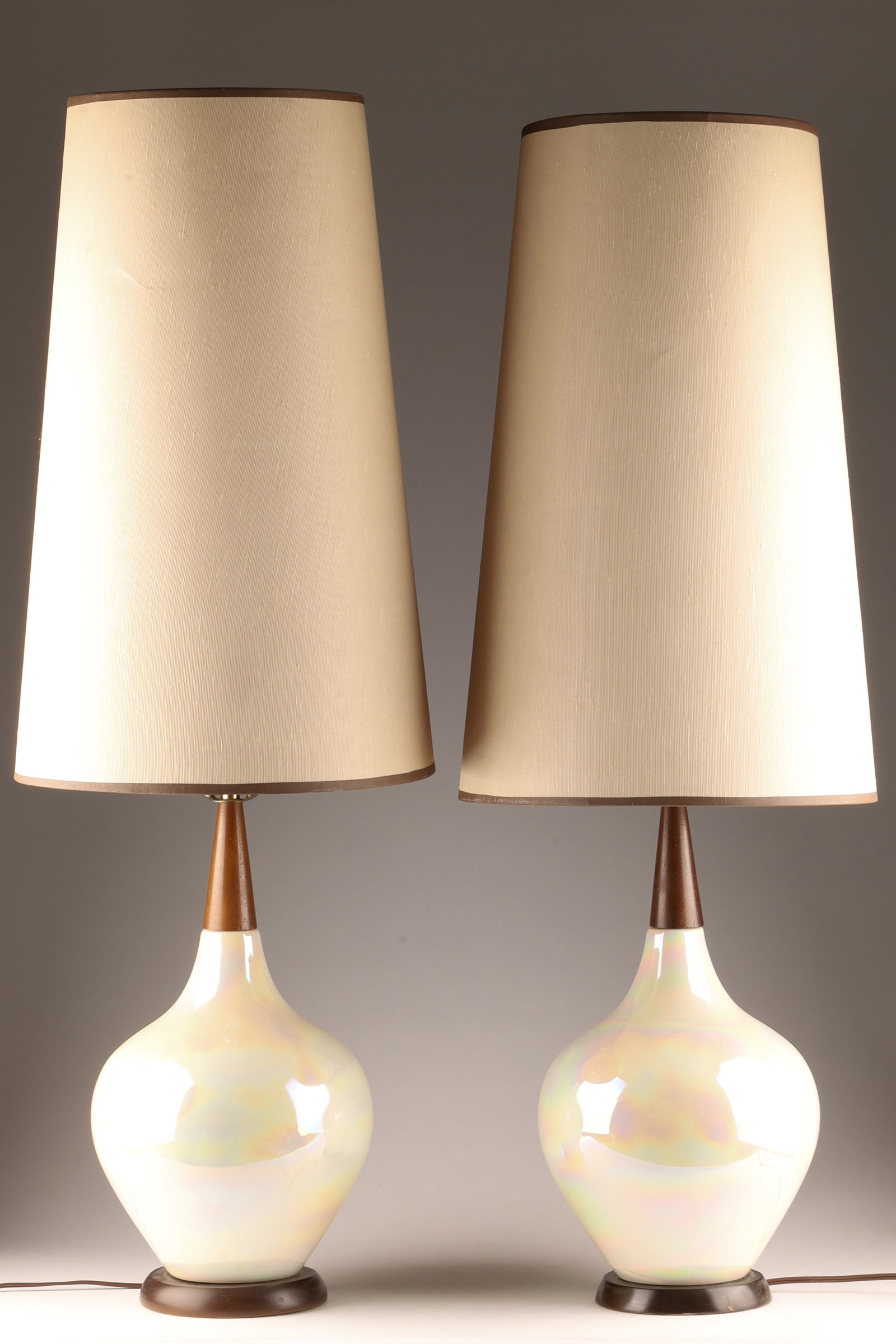 Pair Mid Century Iridescent Ceramic Wood Lamps: Pair Mid Century Iridescent Iridized Milky Ceramic and Wood Lamps with very tall shades. Bases measure 18 inches H, 38 H x 14 inches W with shades.