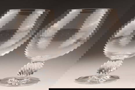 Pair of Lalique Algers Cognac Glasses: Signed Cognac glasses in crystal by Lalique pattern Alger with a decorated foot. 4.75 inches H x 3.5 inches Diameter.