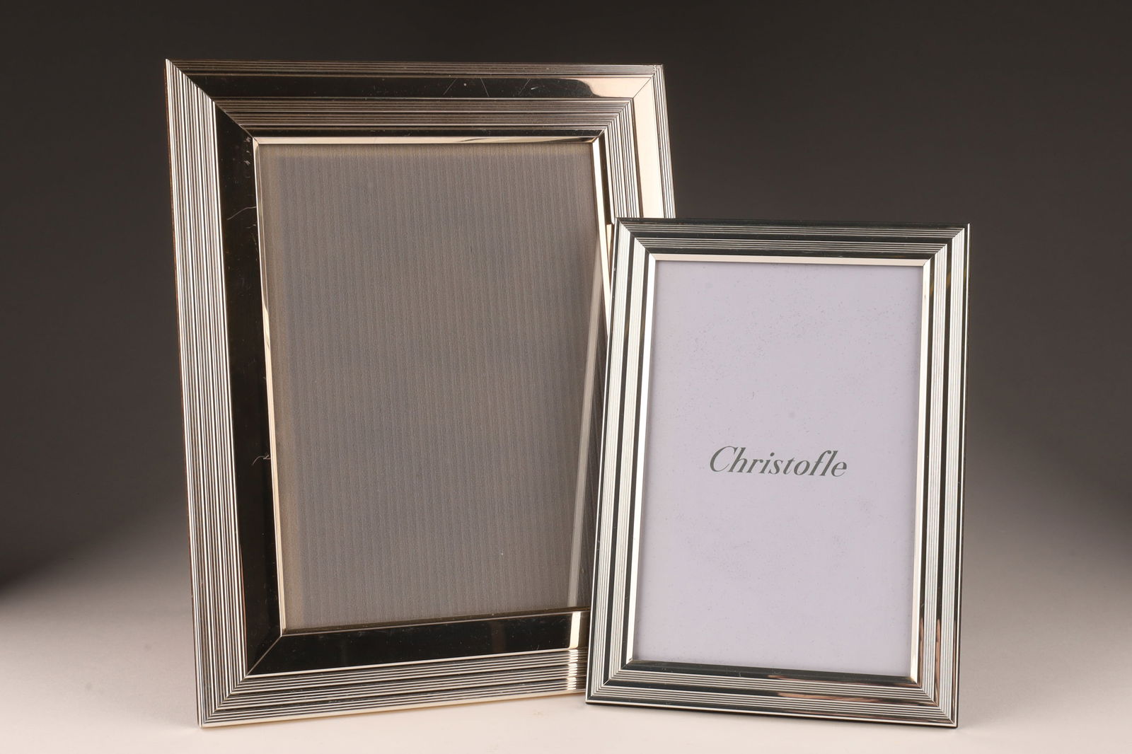 Christofle France Pair Silver Plate Photo Frames: Christofle France pair of Art Deco styled photo picture frames, both marked as in photos, some minor blemishes. Larger frame measures 9.5 x 7.5 inches, smaller frame measures 7.25 x 5.25 inches.